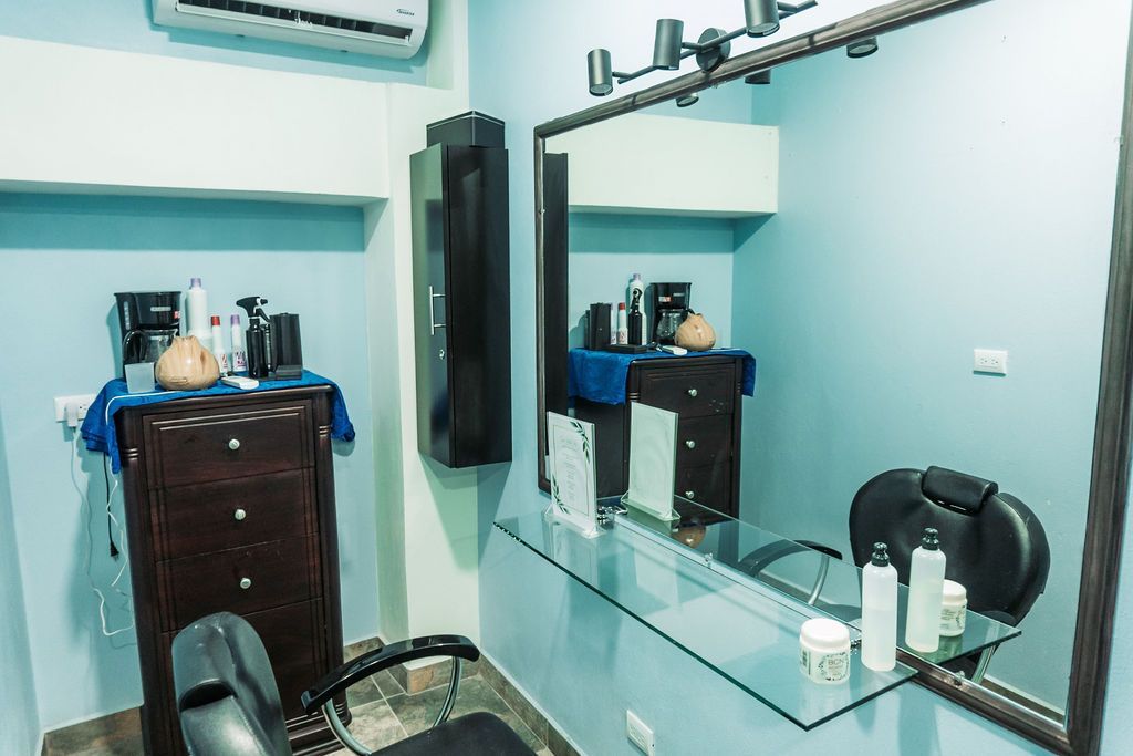 A hair salon with a large mirror and a chair.