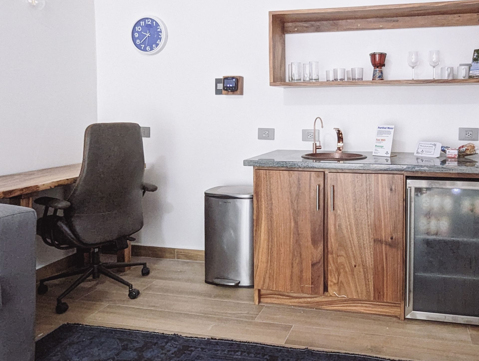 A kitchen with a clock on the wall above the sink