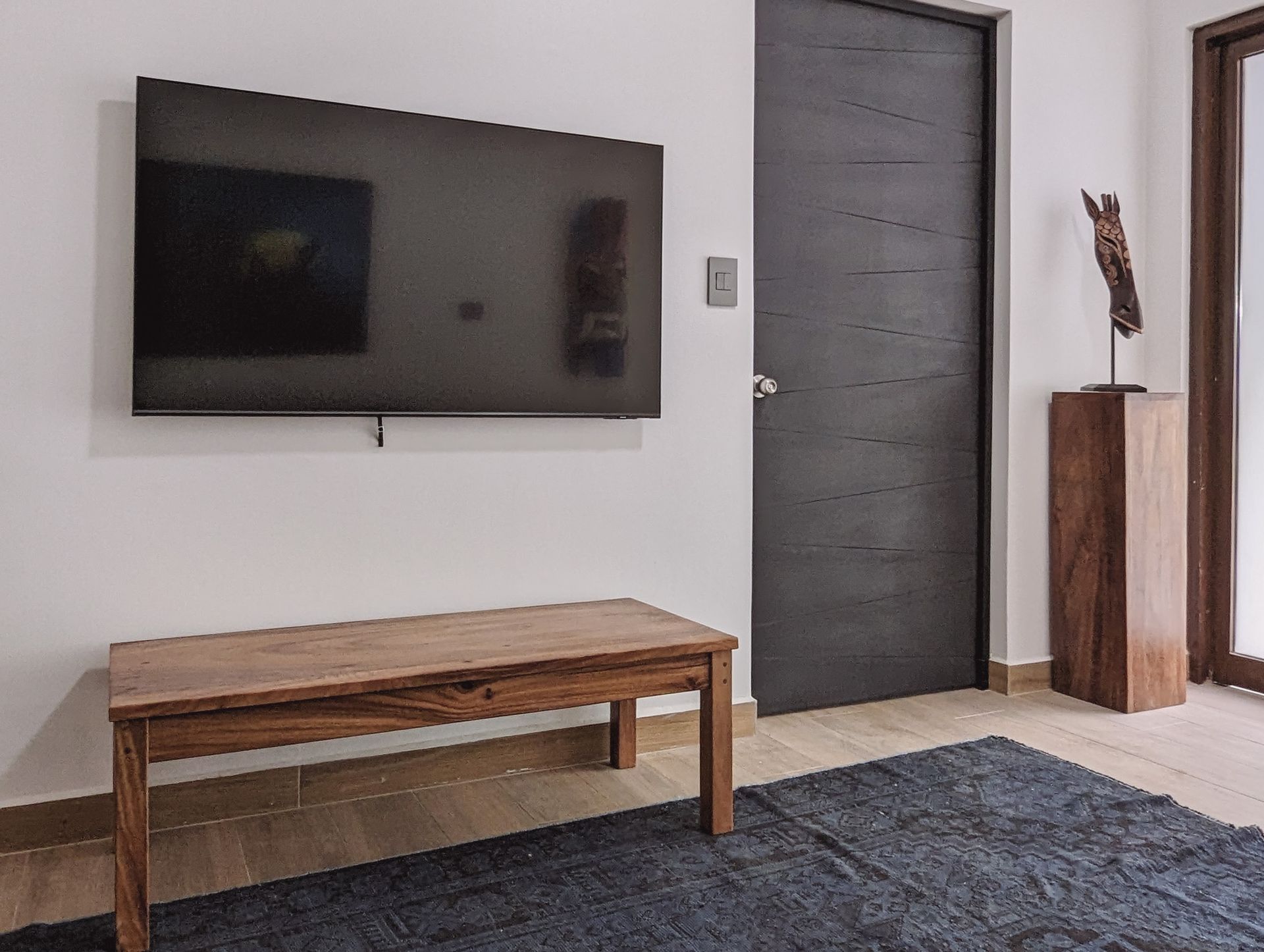 A living room with a flat screen tv mounted on the wall.
