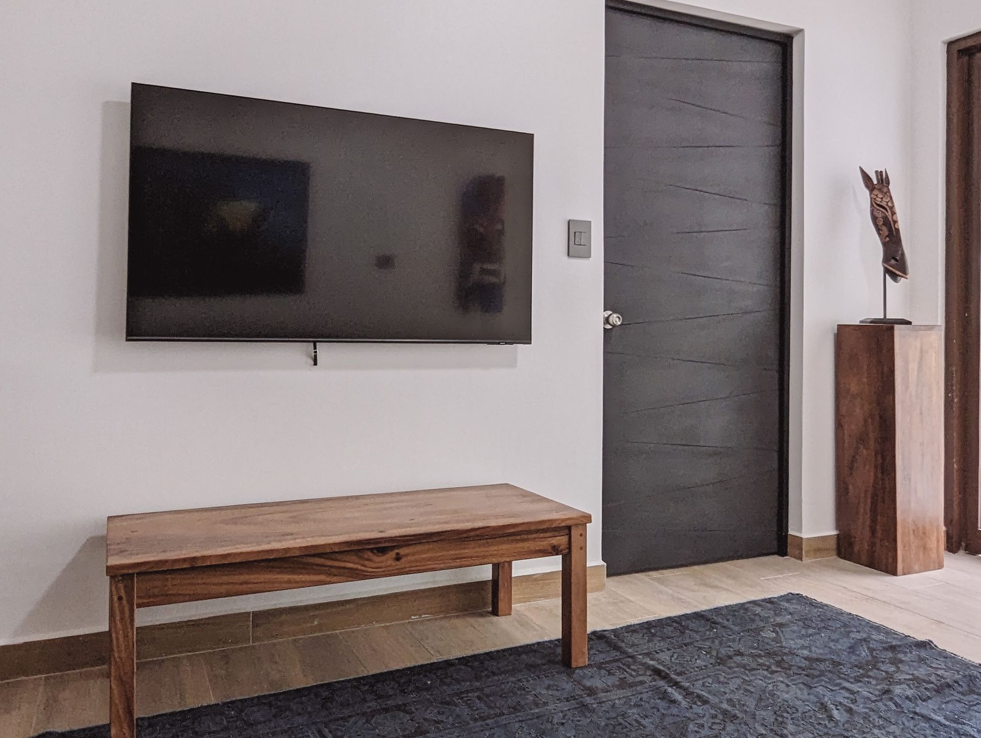 A living room with a flat screen tv mounted on the wall.