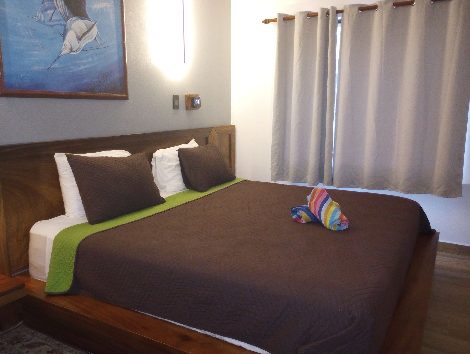 A hotel room with a large bed and a painting on the wall