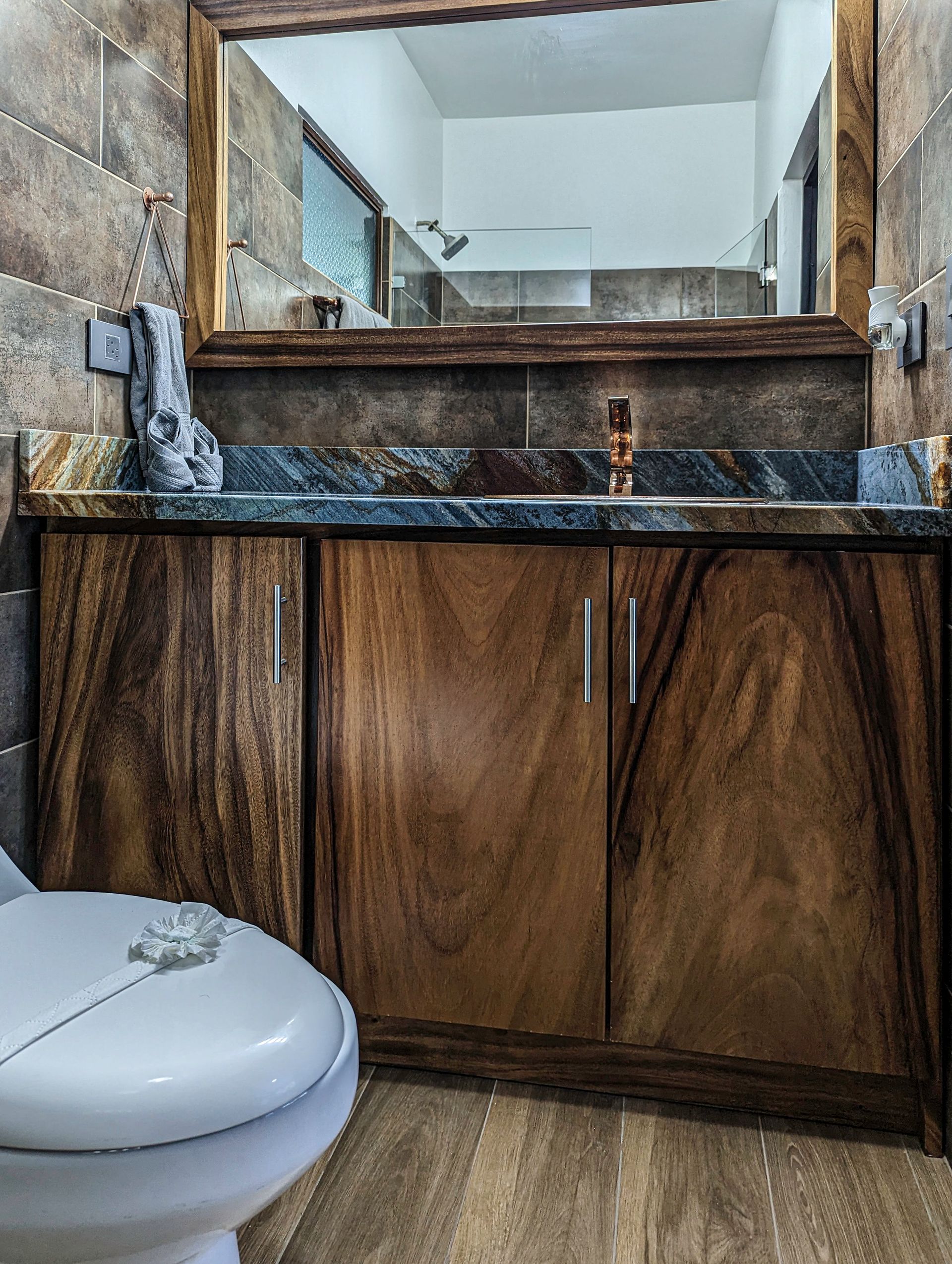 A bathroom with a toilet a sink and a mirror