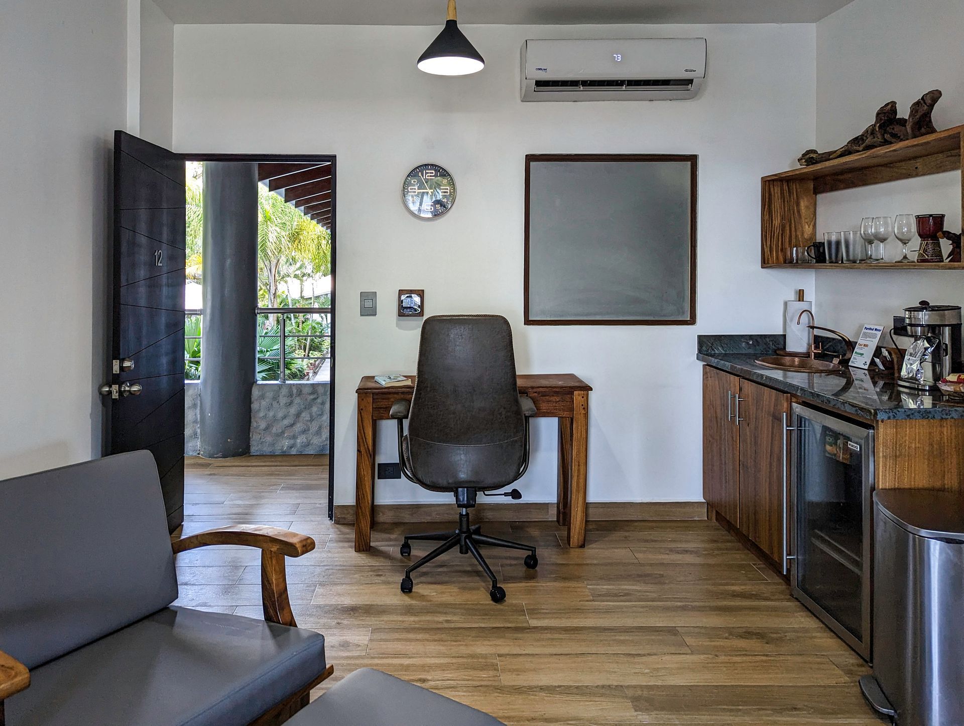 A living room with a desk , chair and couch.
