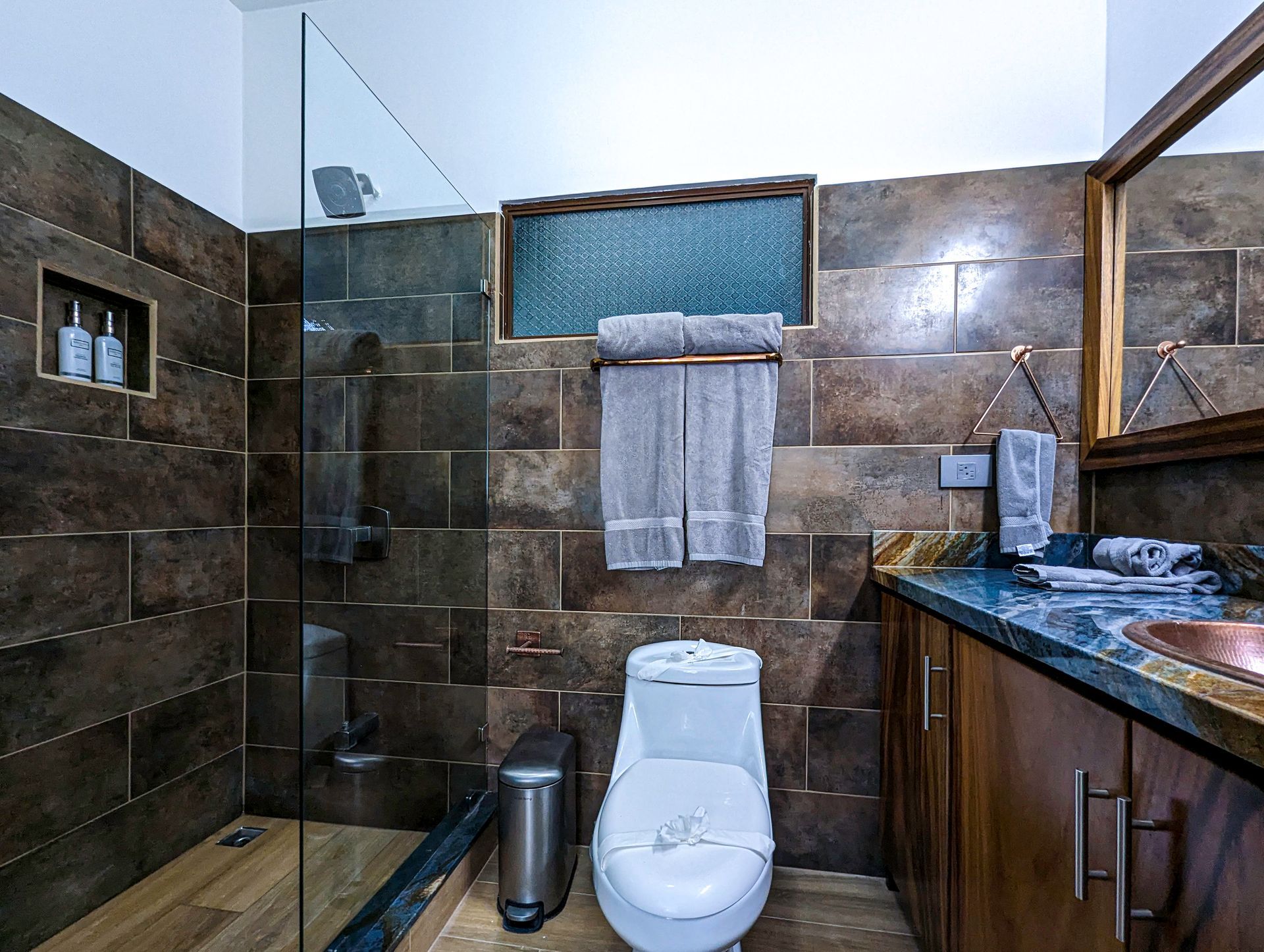 A bathroom with a toilet , sink , and shower.