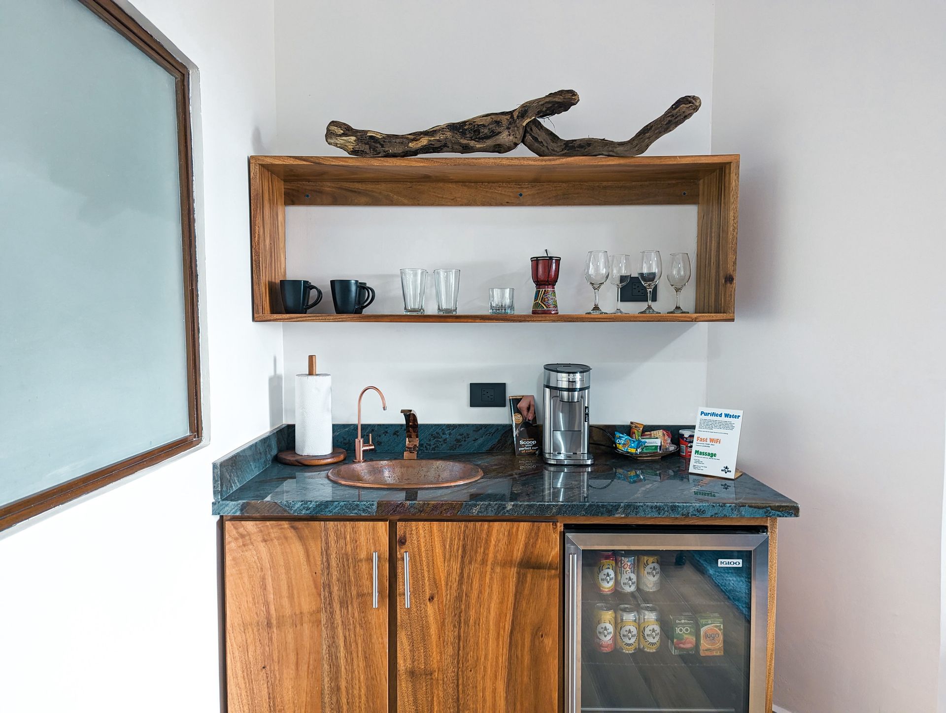 A small kitchen with a sink , refrigerator , and shelf.