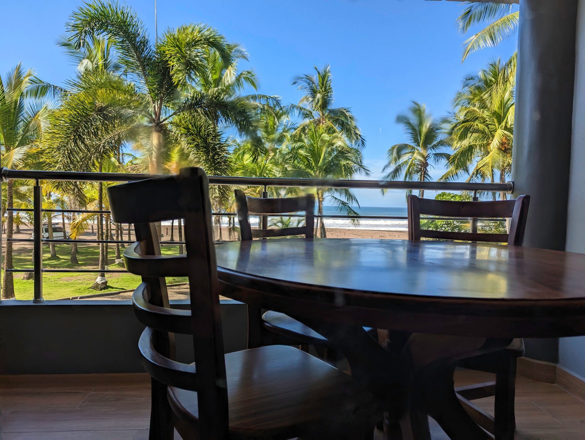 A table and chairs on a balcony overlooking the ocean