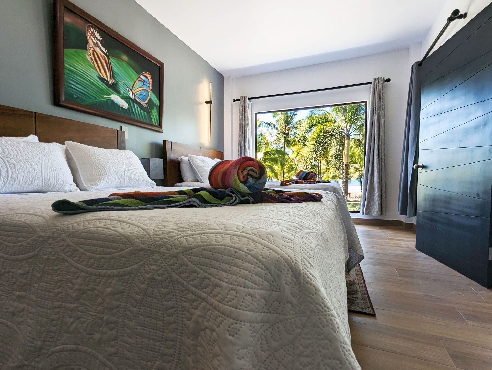 A hotel room with two beds and a painting on the wall