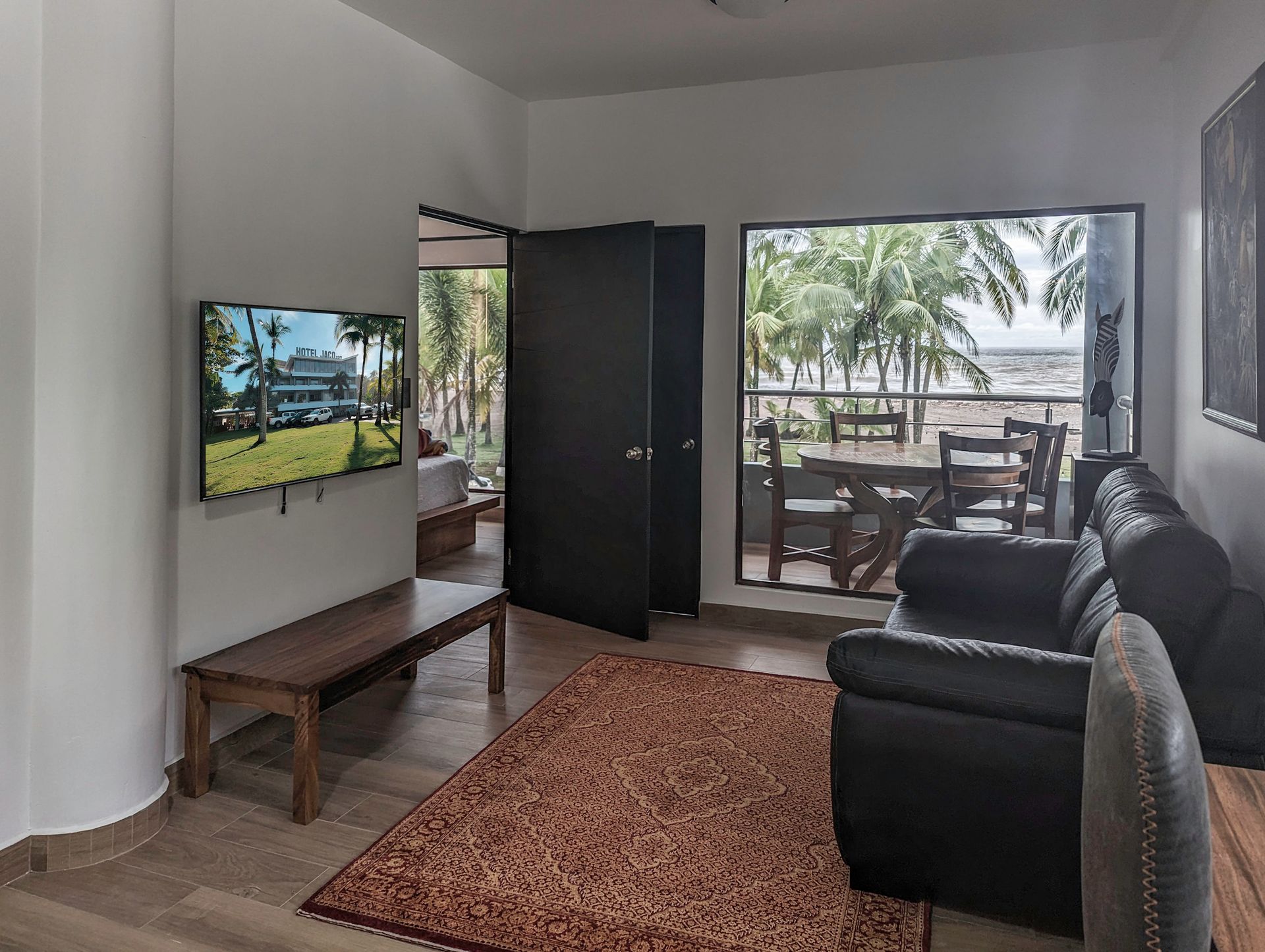 A living room with a couch , chair , table and television.
