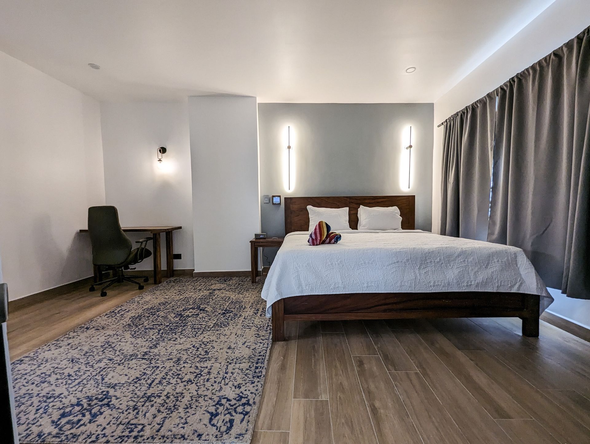 A hotel room with a large bed and a desk