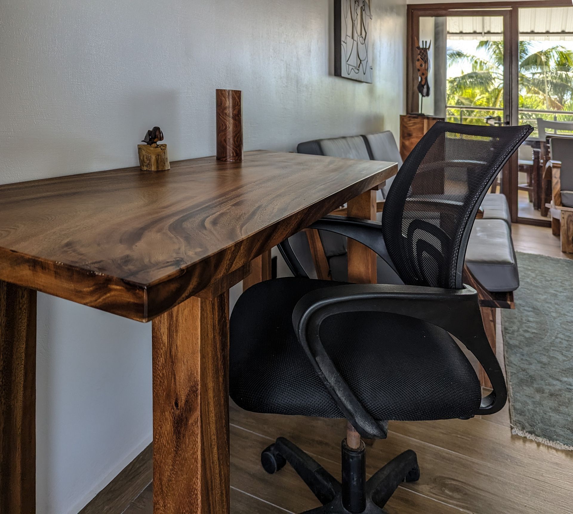 A wooden desk with a black chair underneath it