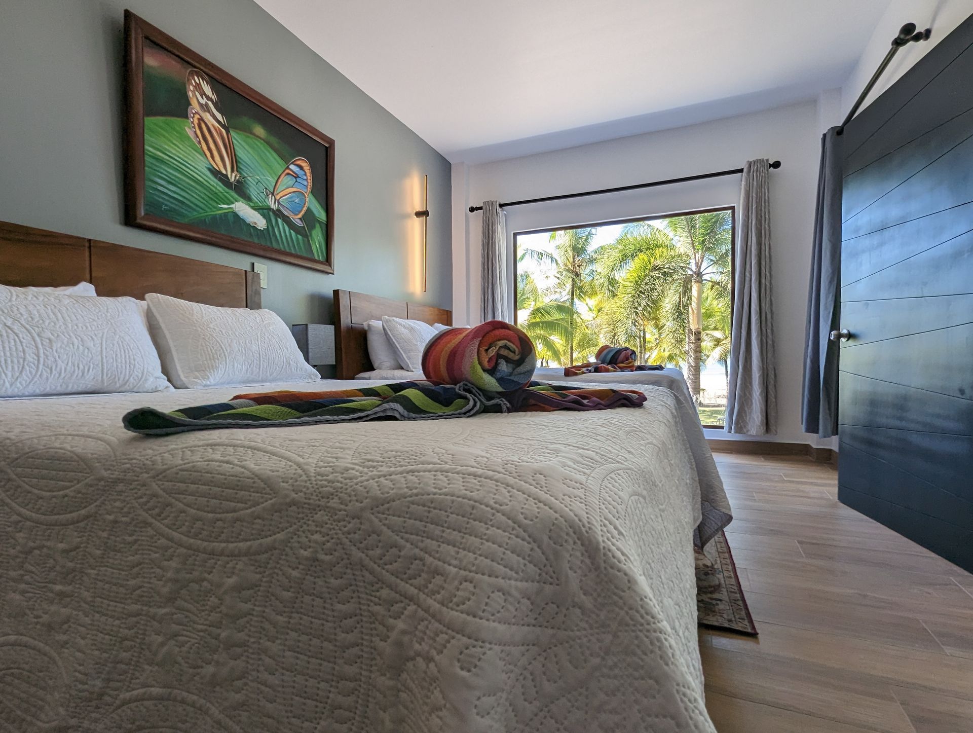 A bedroom with a large bed and a painting on the wall.