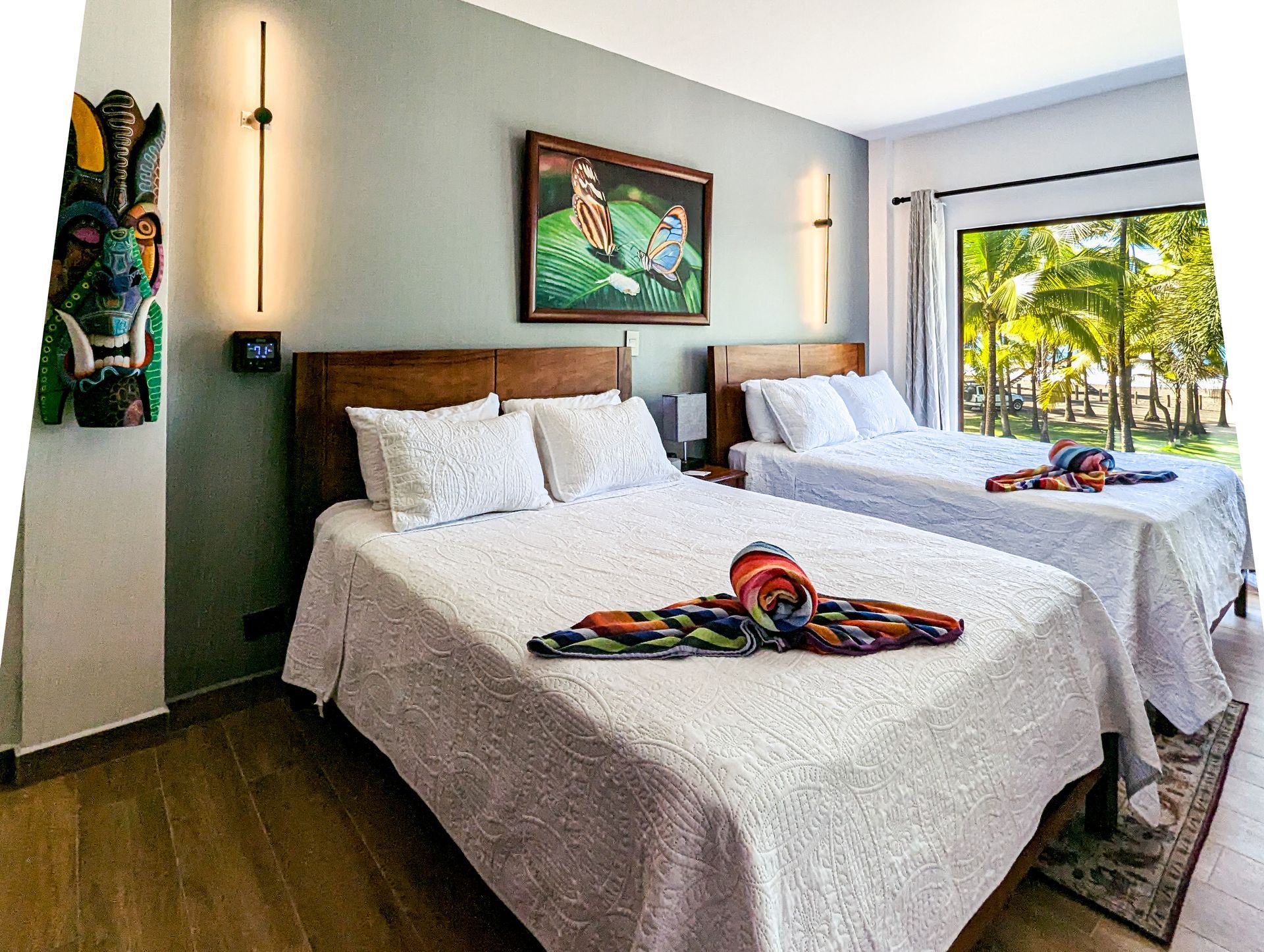 A hotel room with two beds and a painting on the wall.