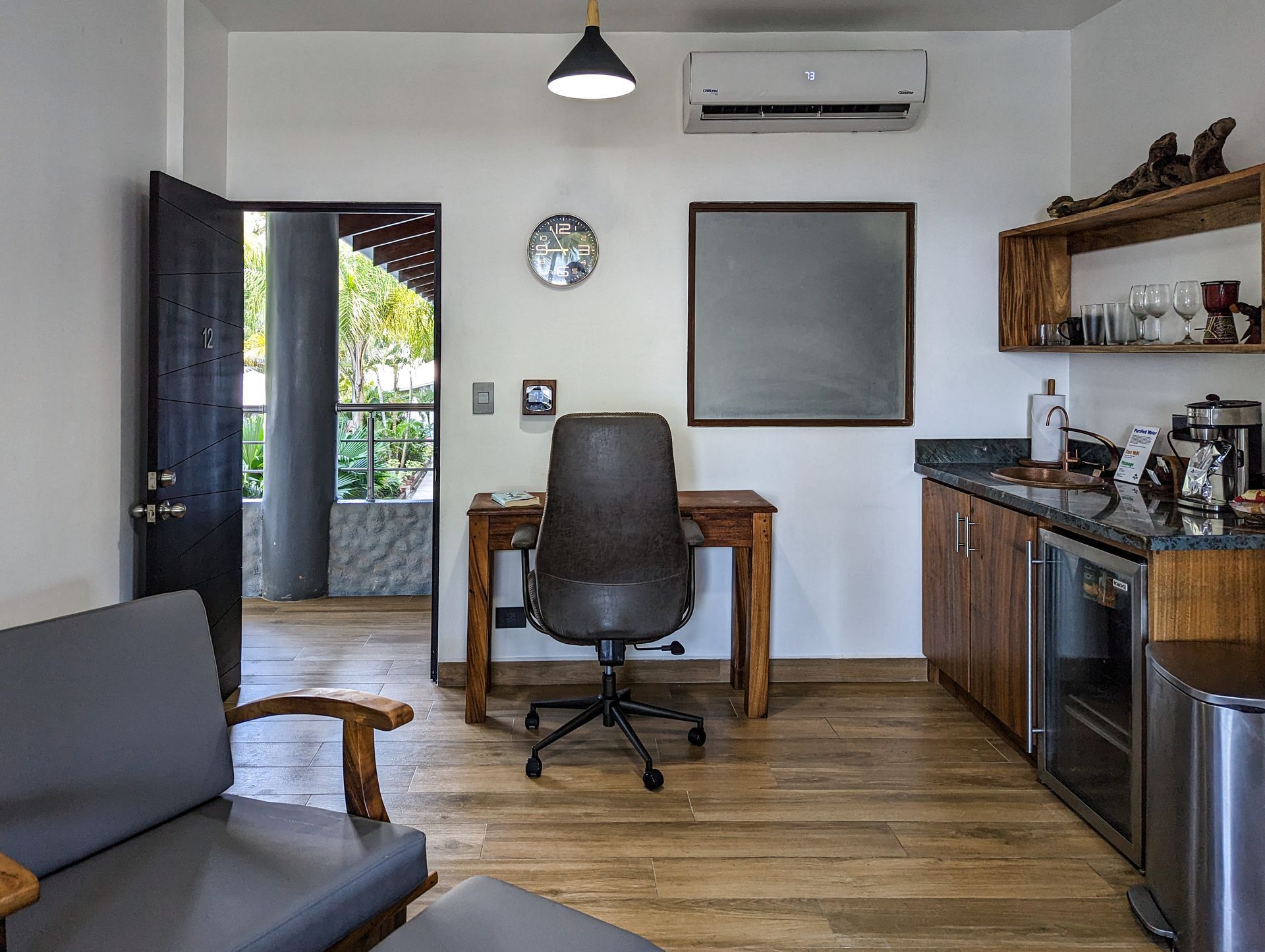 A living room with a desk , chair and couch.
