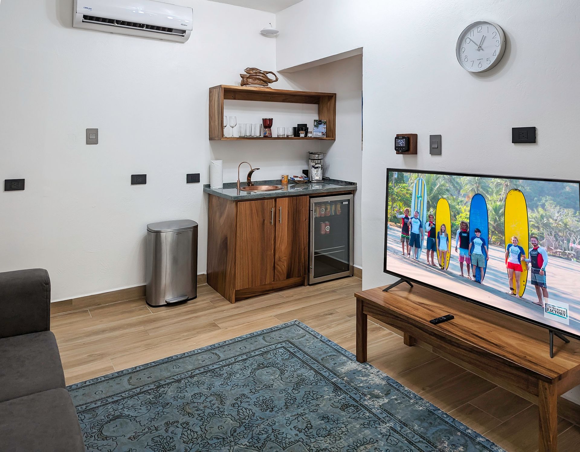 A living room with a flat screen tv and a clock on the wall