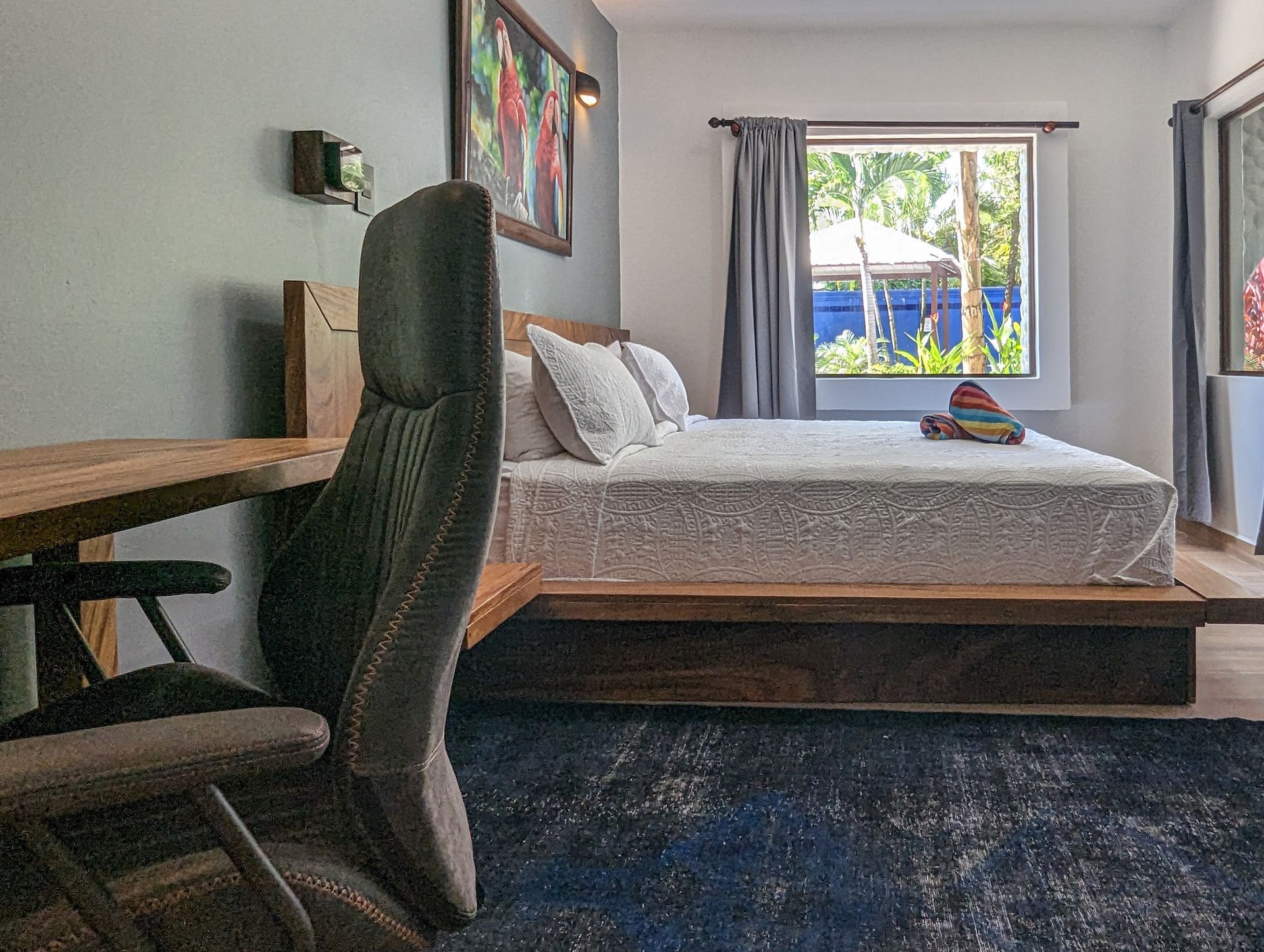 A bedroom with a bed , desk , chair and window.