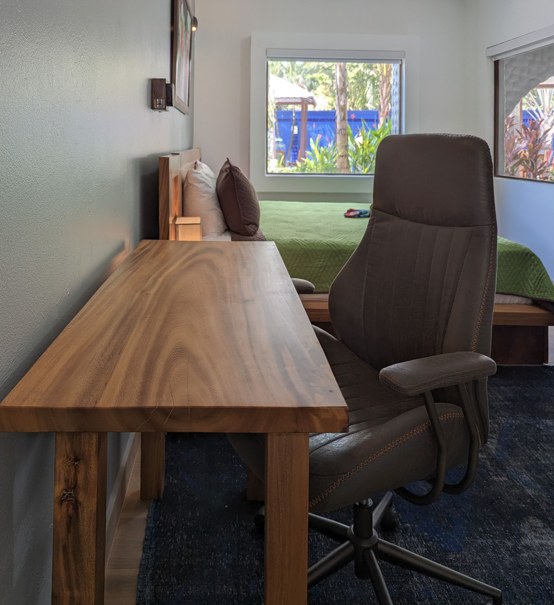 A chair sits next to a wooden desk in a bedroom
