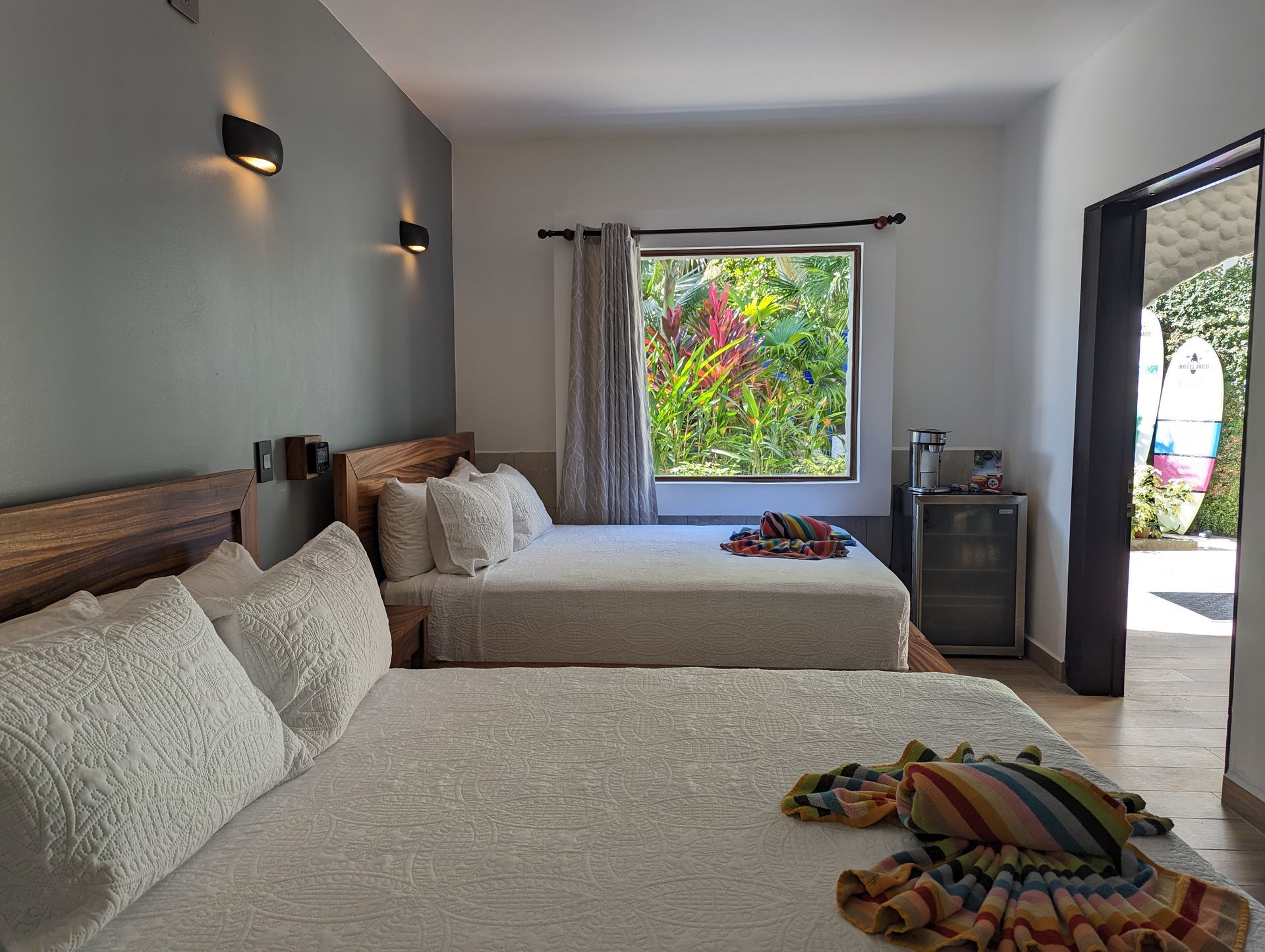 A hotel room with two beds and a window.