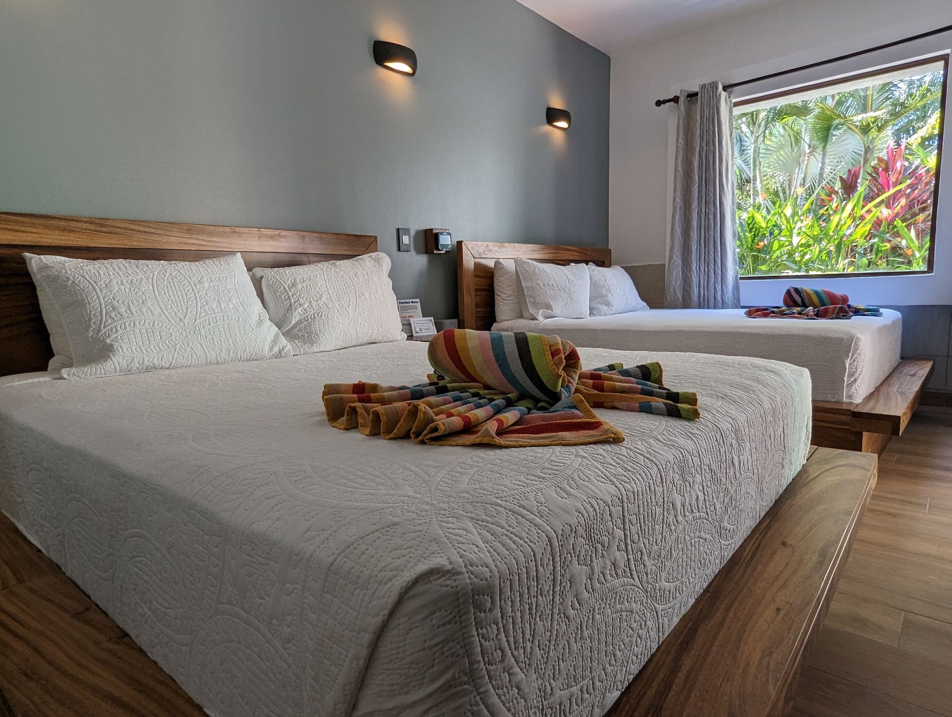 A hotel room with two beds and a window.