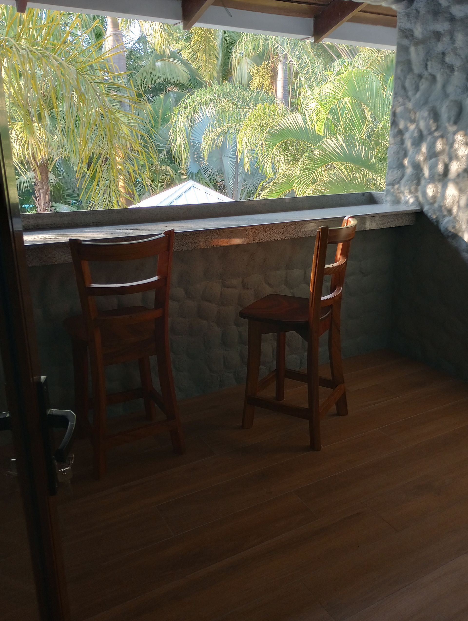 A room with two chairs and a table with a view of trees.