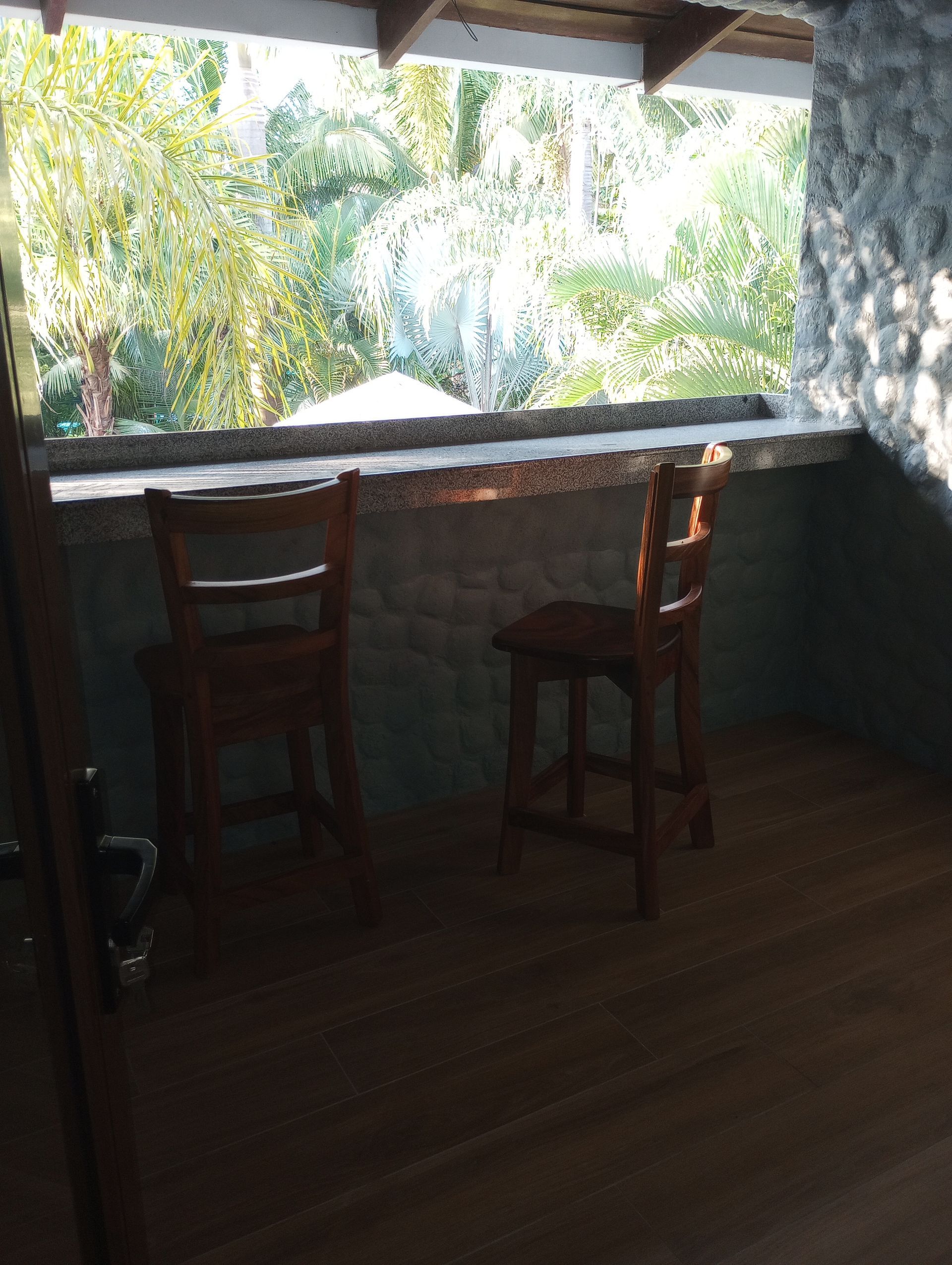 A room with two chairs and a table with a view of trees.