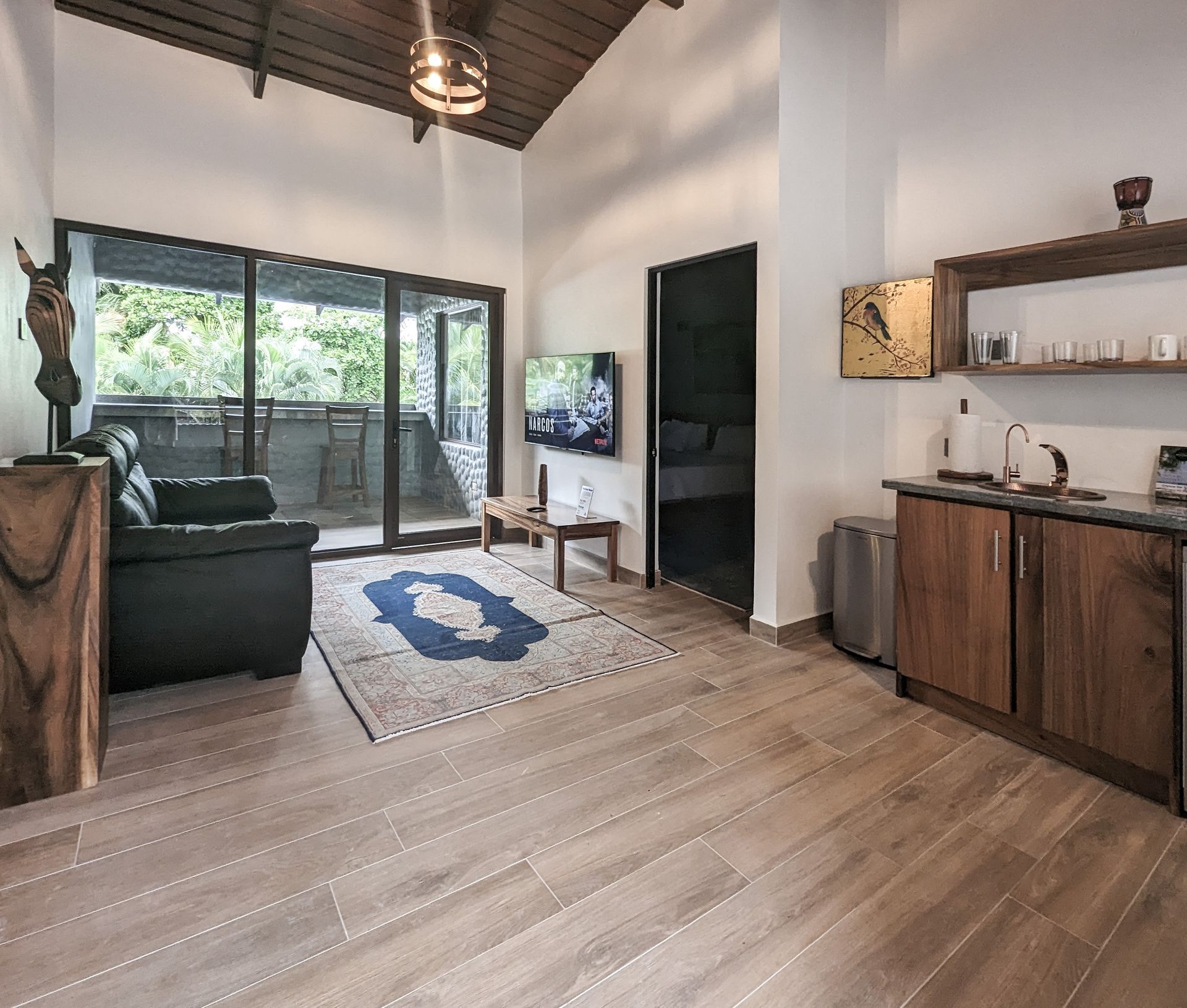 A living room with a black couch and a flat screen tv