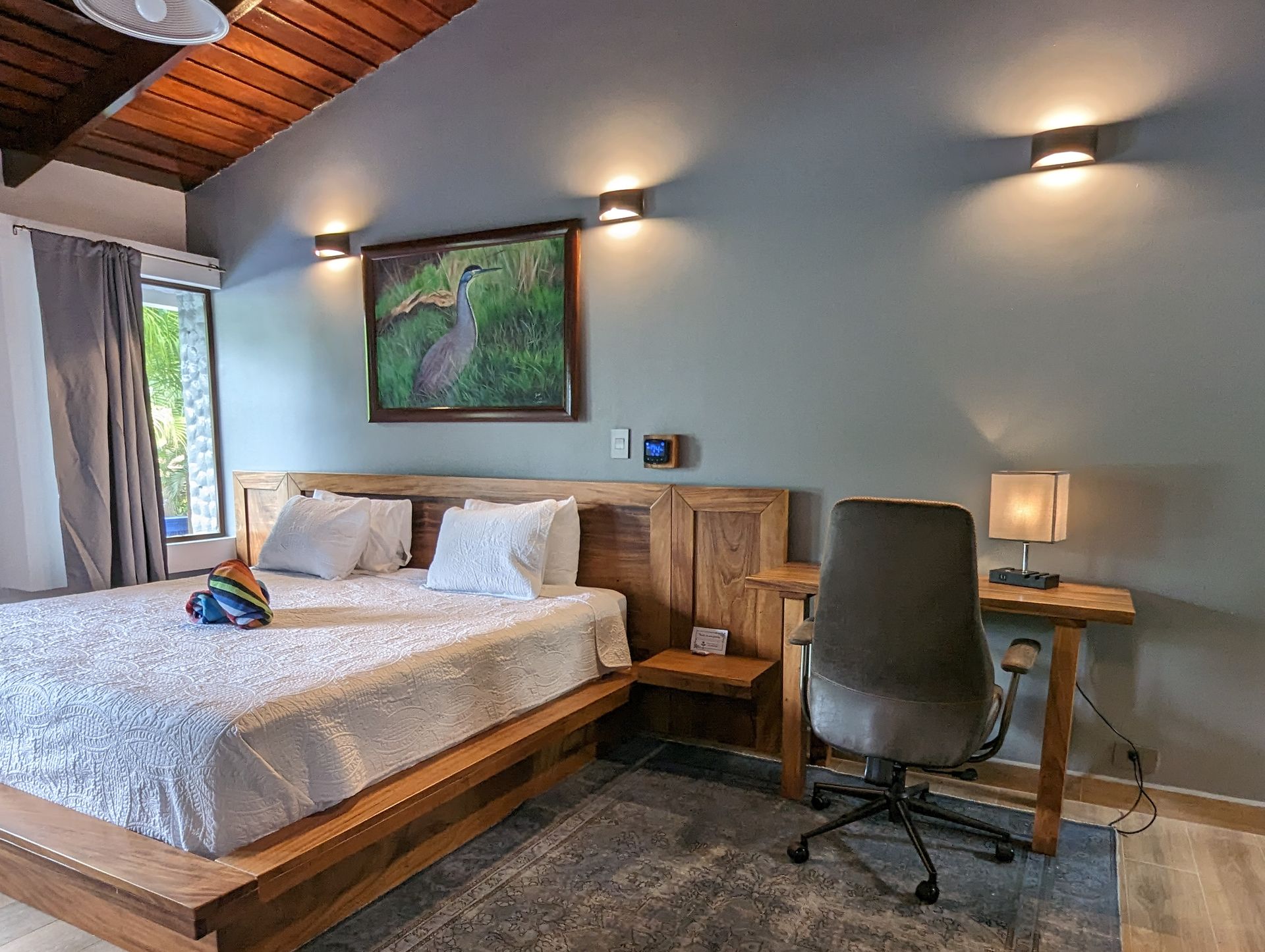 A bedroom with a large bed , desk and chair.