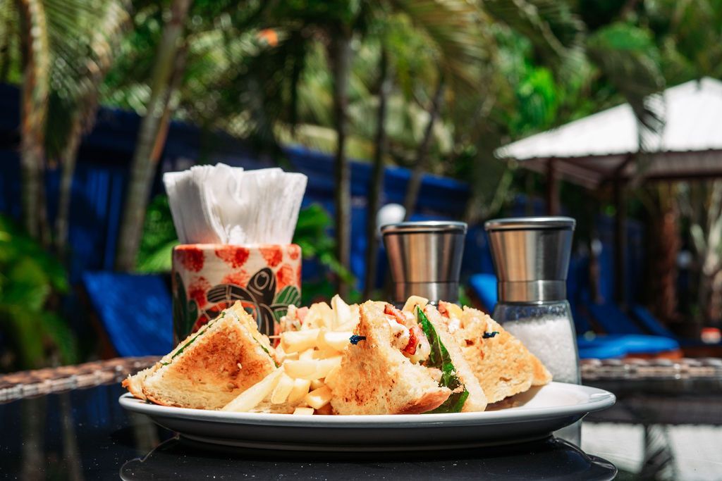 A white plate topped with sandwiches and french fries on a table.
