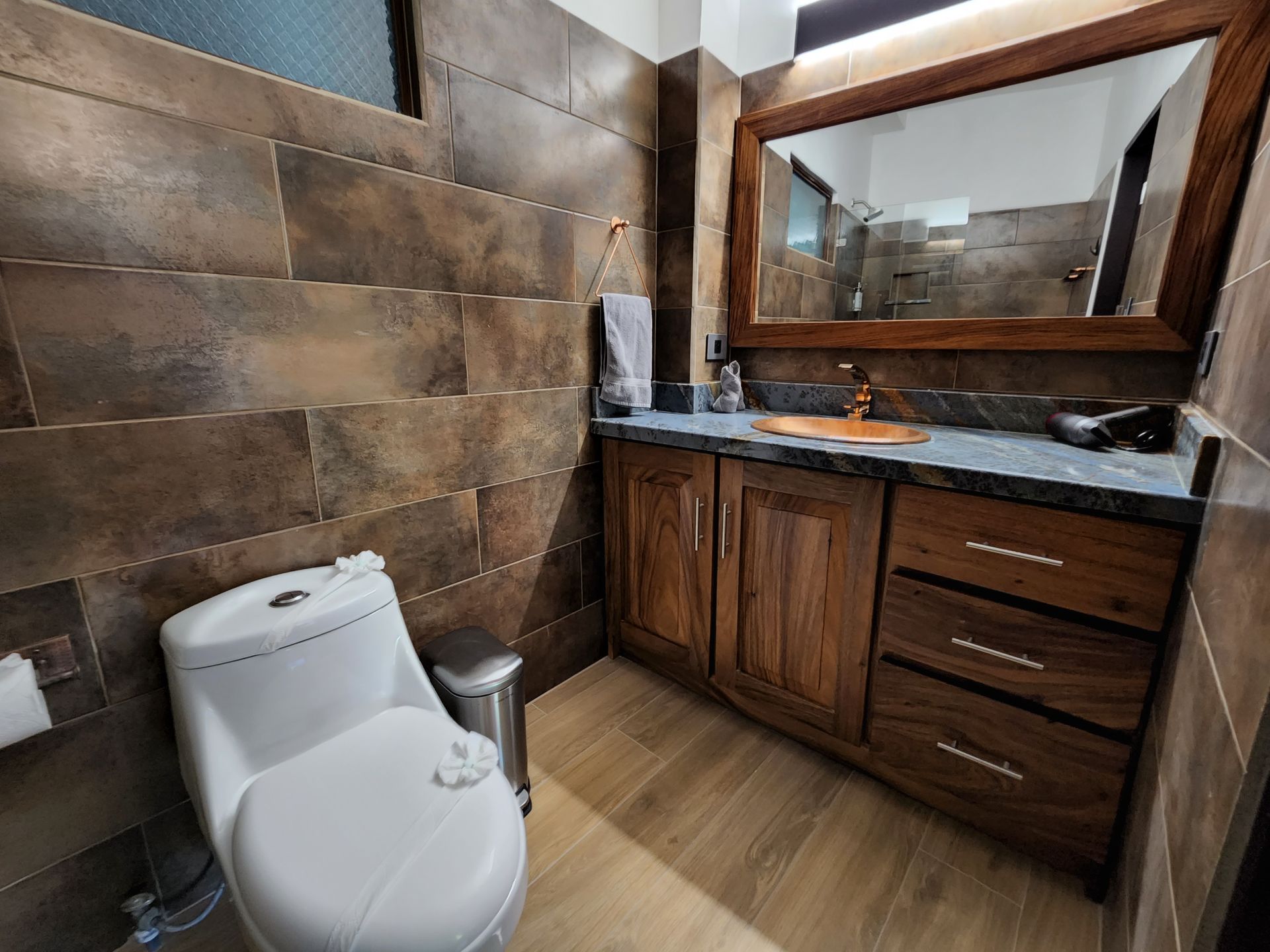 A bathroom with a toilet , sink and mirror