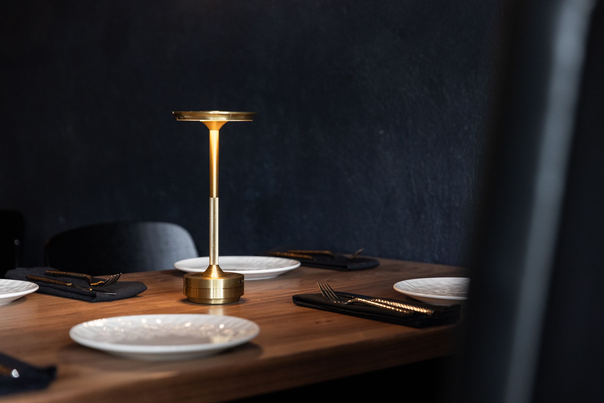 A table with plates and a lamp on it.