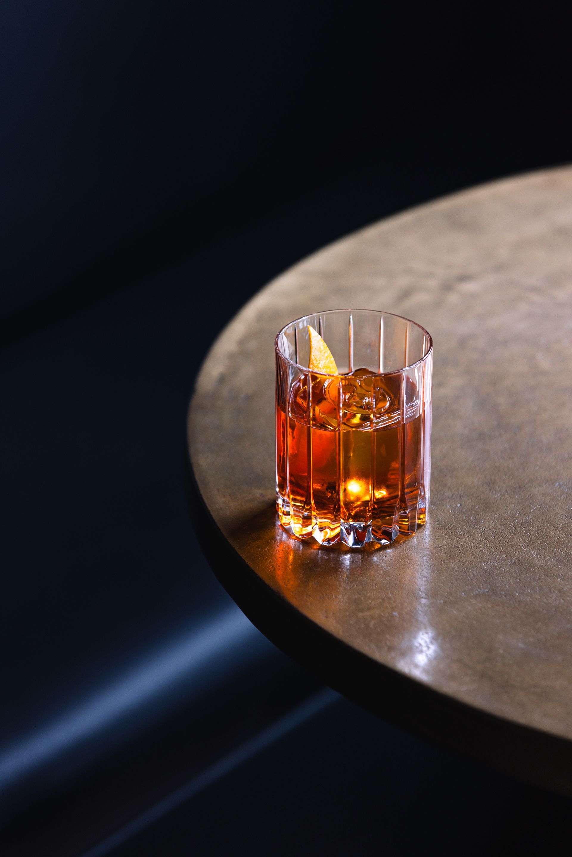 A close up of a glass of whiskey on a table.