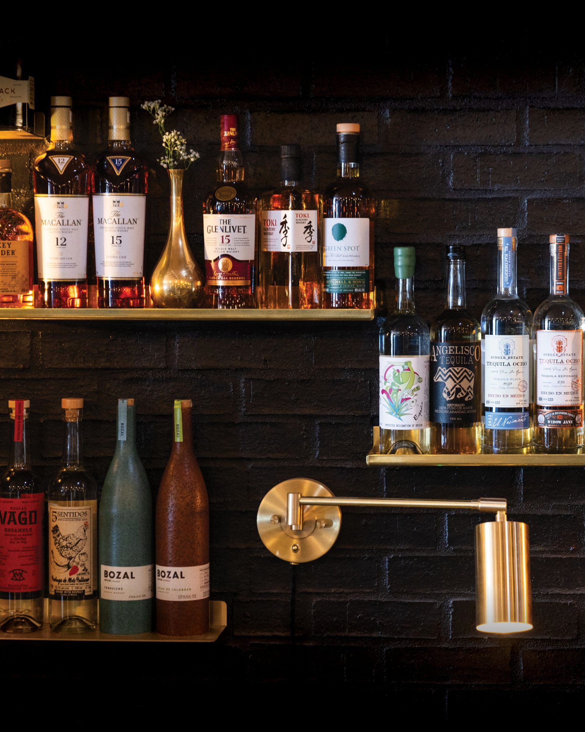 Several bottles of alcohol are on a shelf including a bottle of glenfiddich