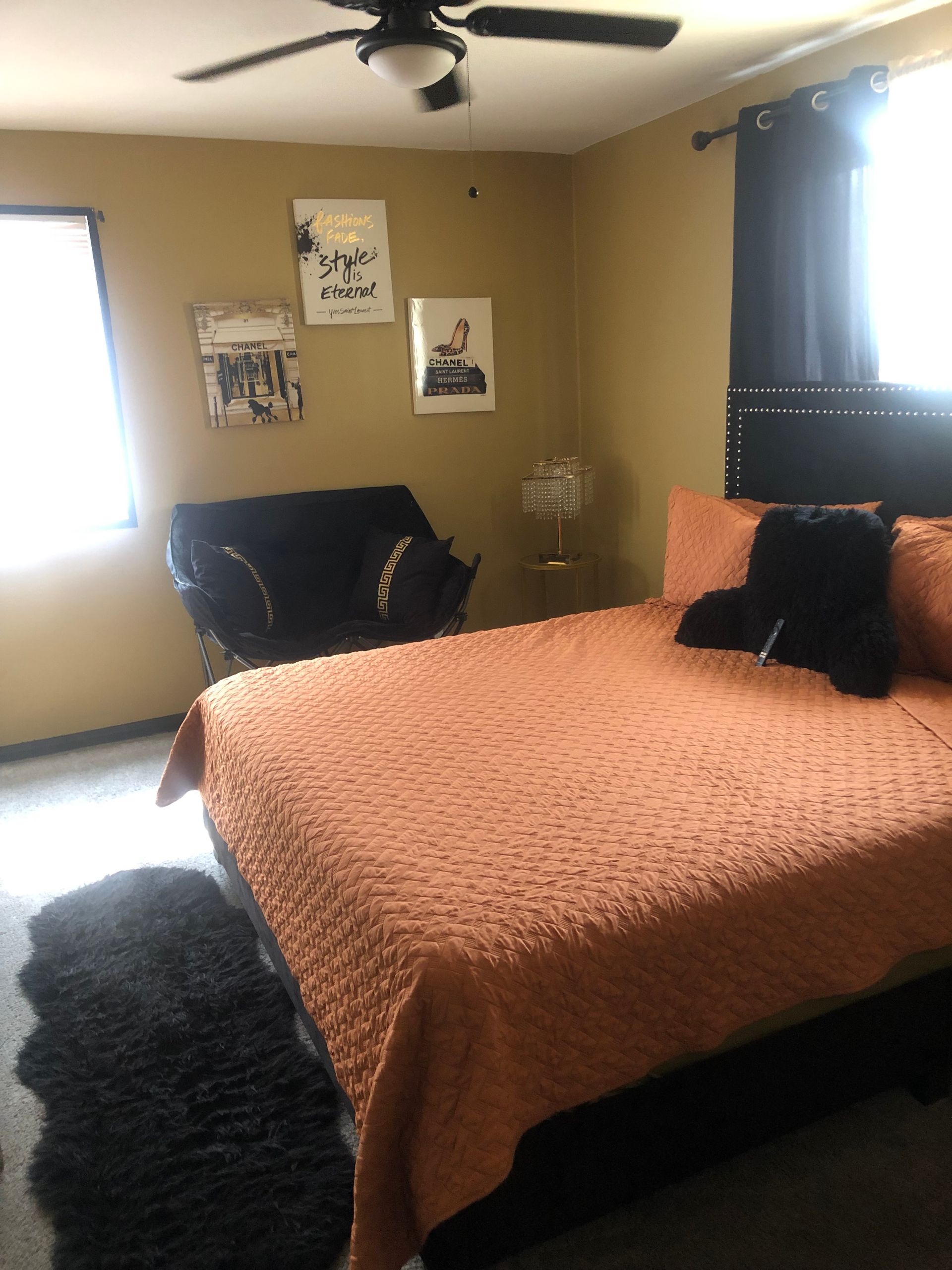 a bedroom with a bed a chair and a ceiling fan