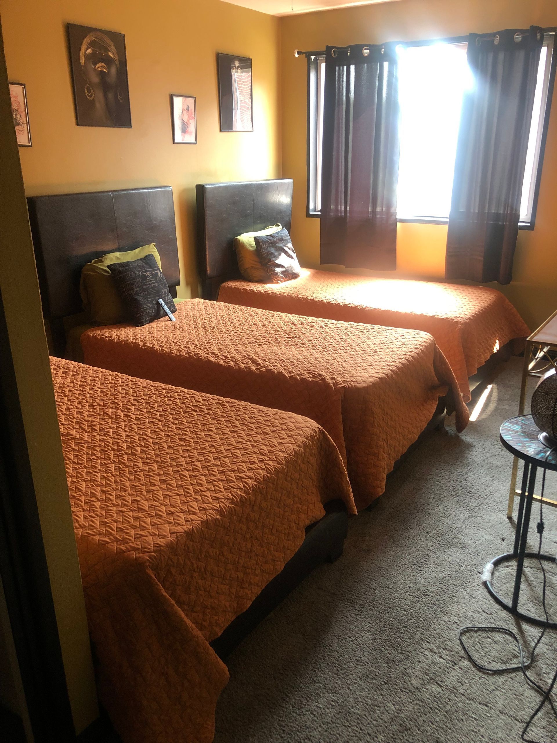 a bedroom with three beds and a window