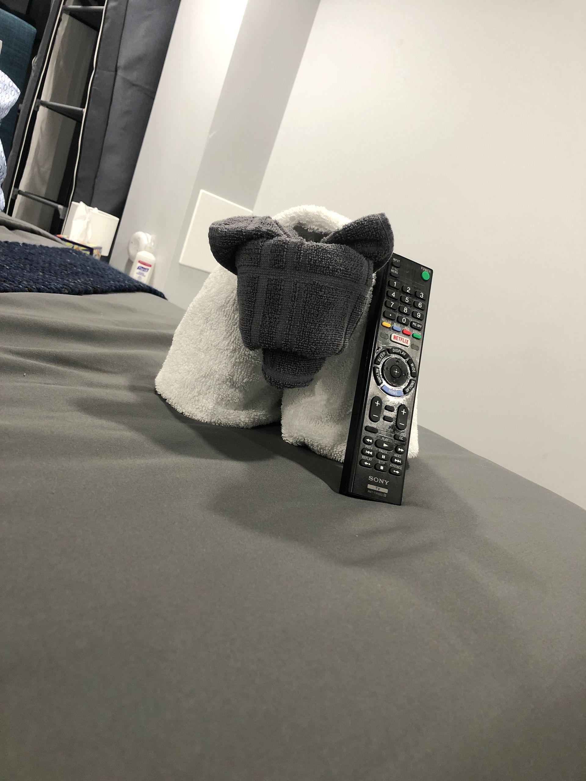 a remote control is sitting on a bed next to a stuffed animal .