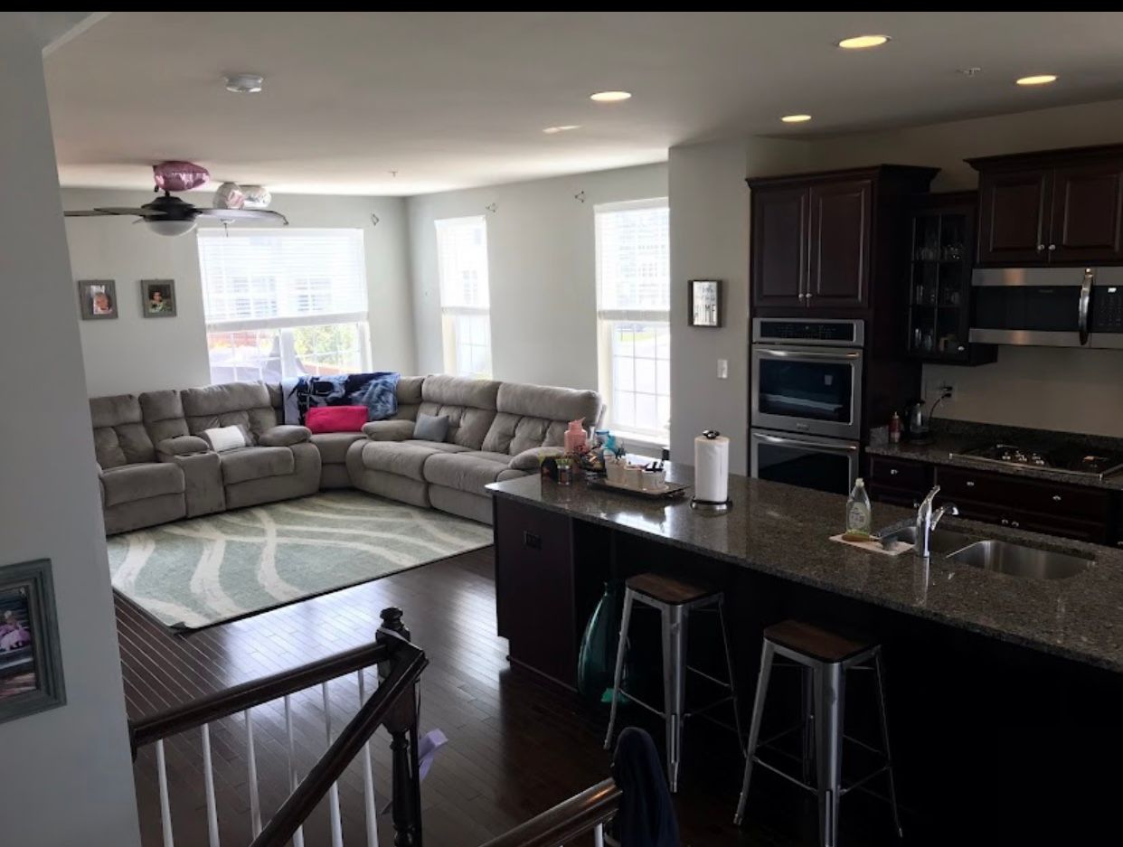 a living room with a large sectional couch and a kitchen .