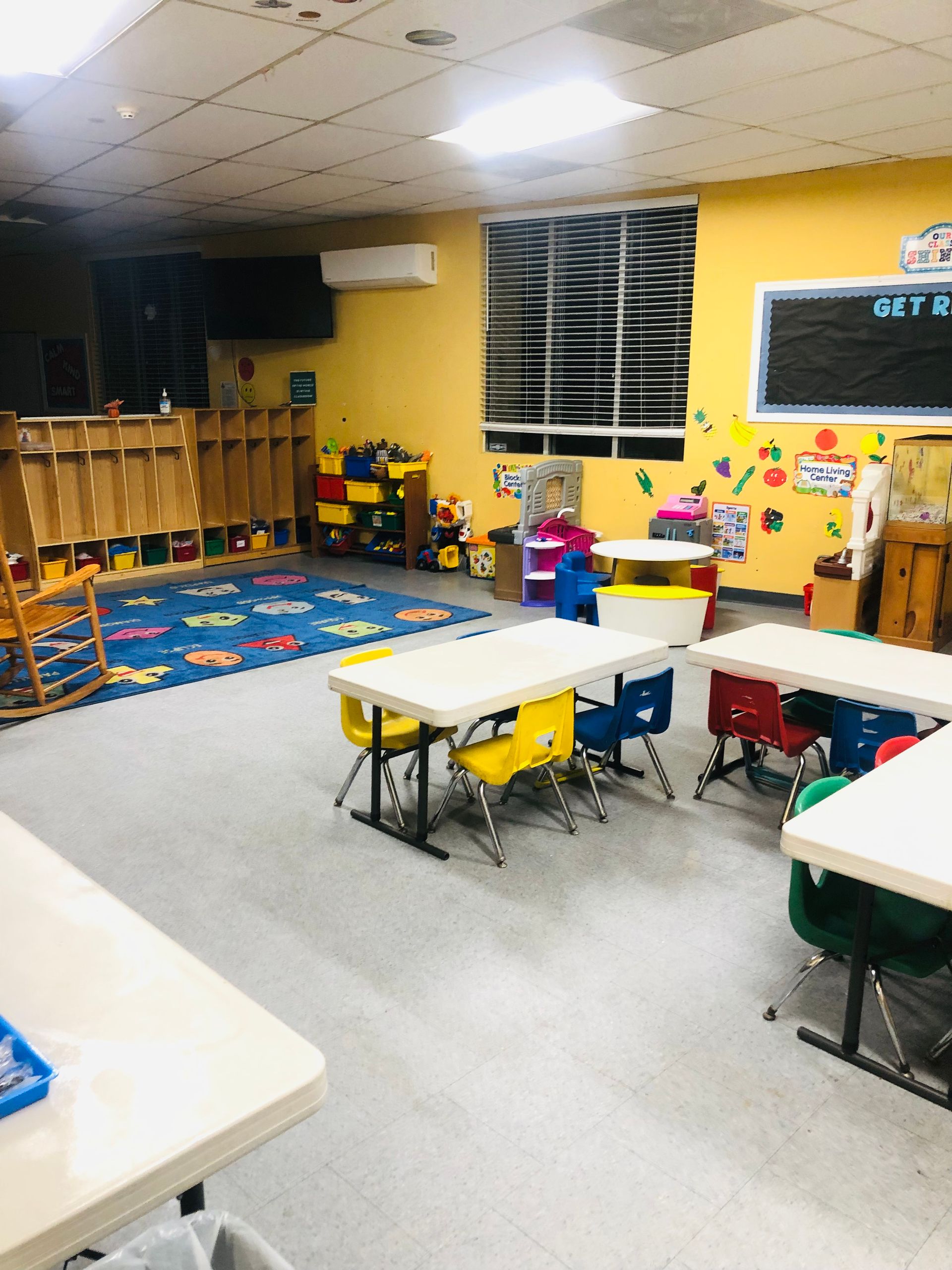 a classroom with tables and chairs and a chalkboard that says