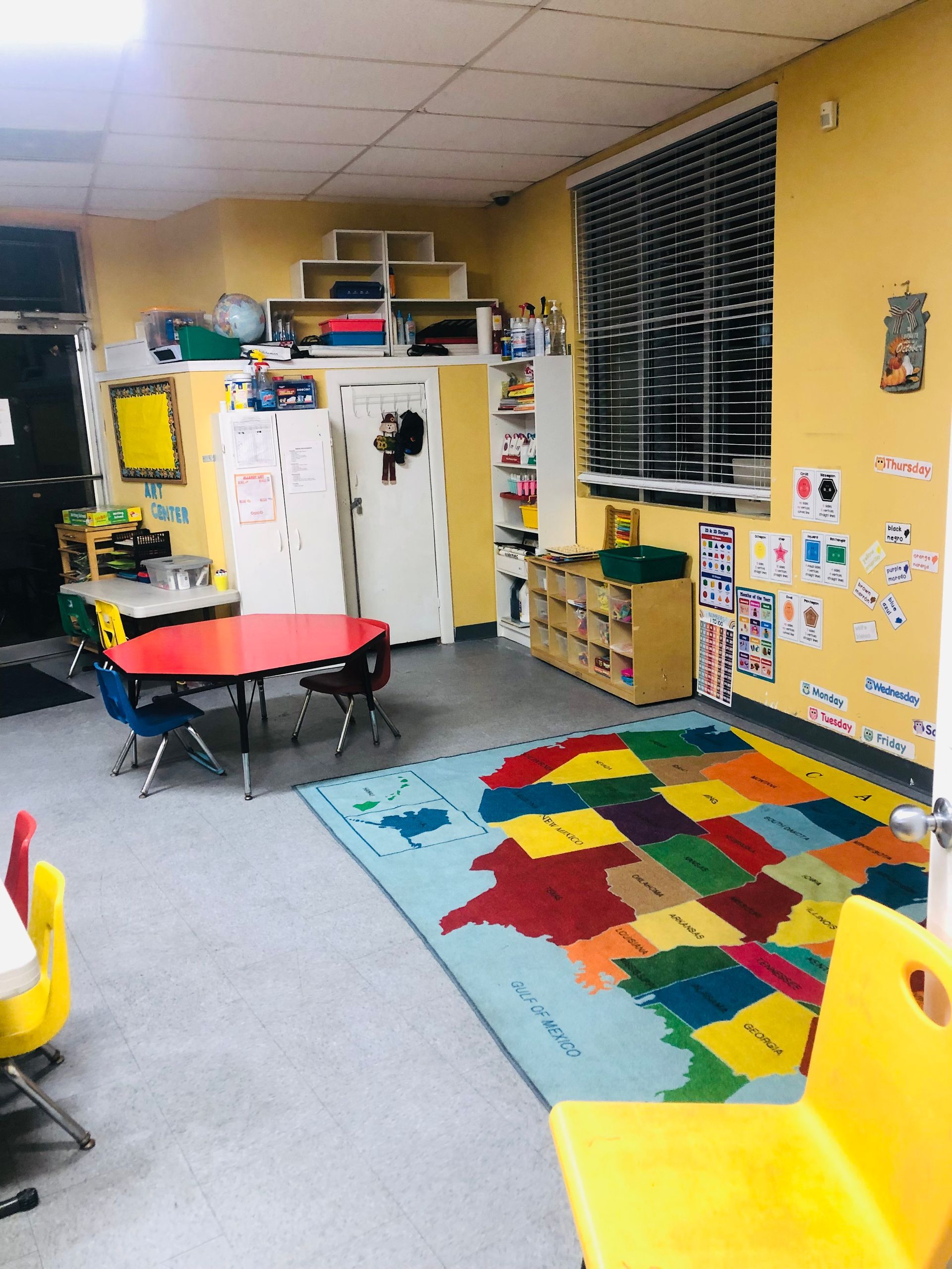a classroom with a colorful rug and a map on the floor
