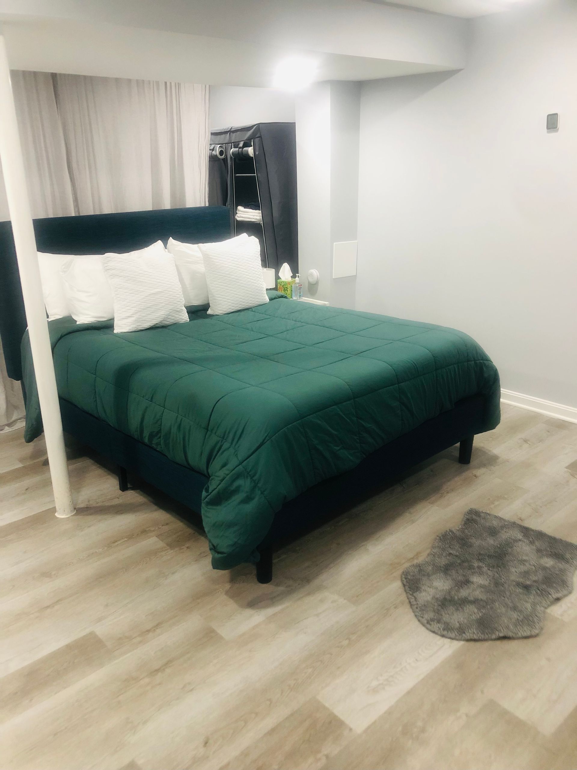 a bedroom with a bed and a rug on the floor