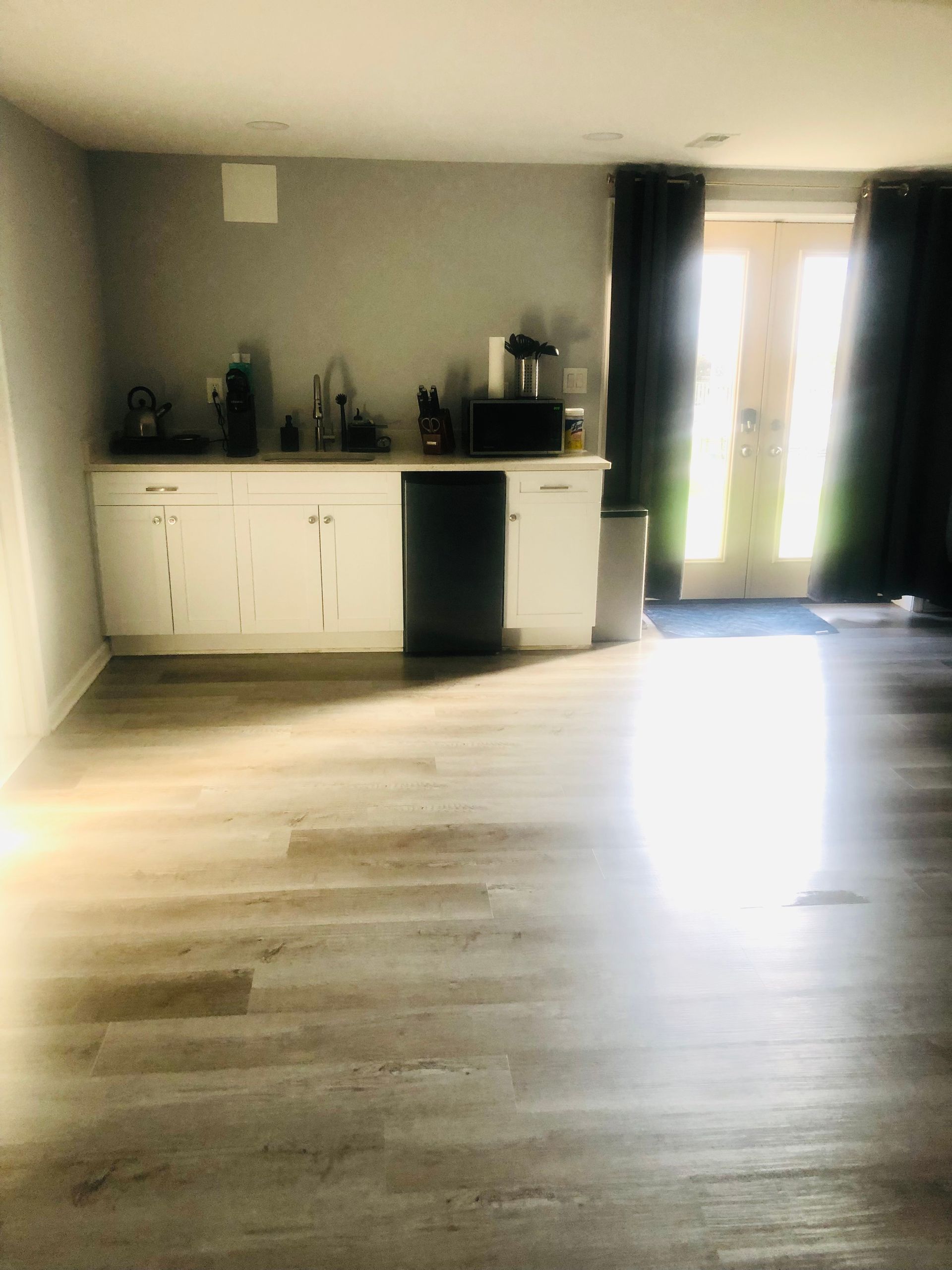a kitchen with white cabinets and a black dishwasher