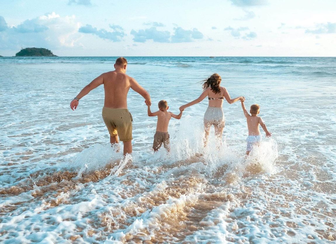 Familie genießt Strandurlaub nach der Einnahme von Familienrabatt
