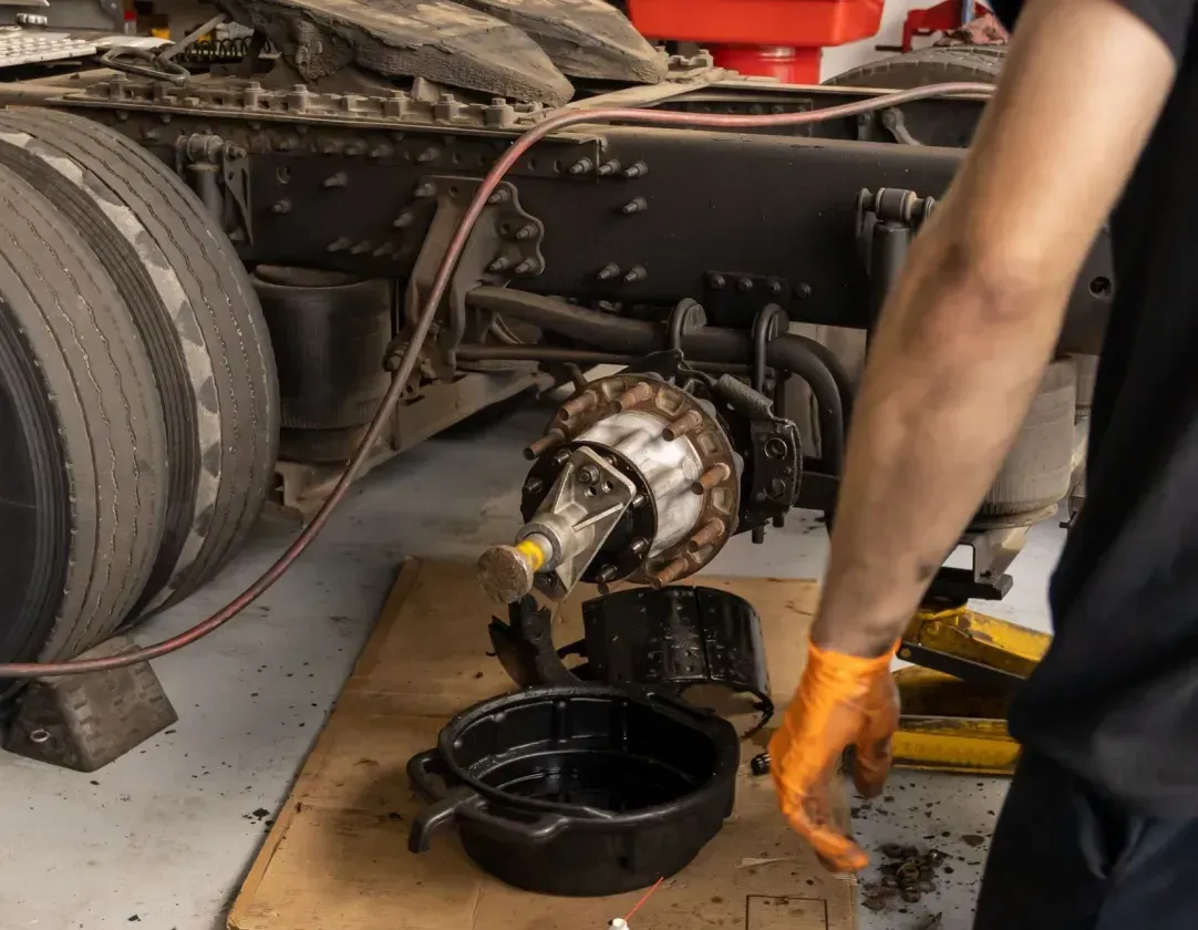A man is working on a truck in a garage.