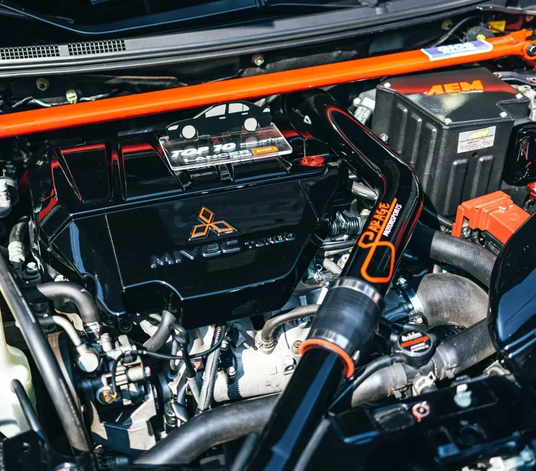 A close up of a car engine with the hood open