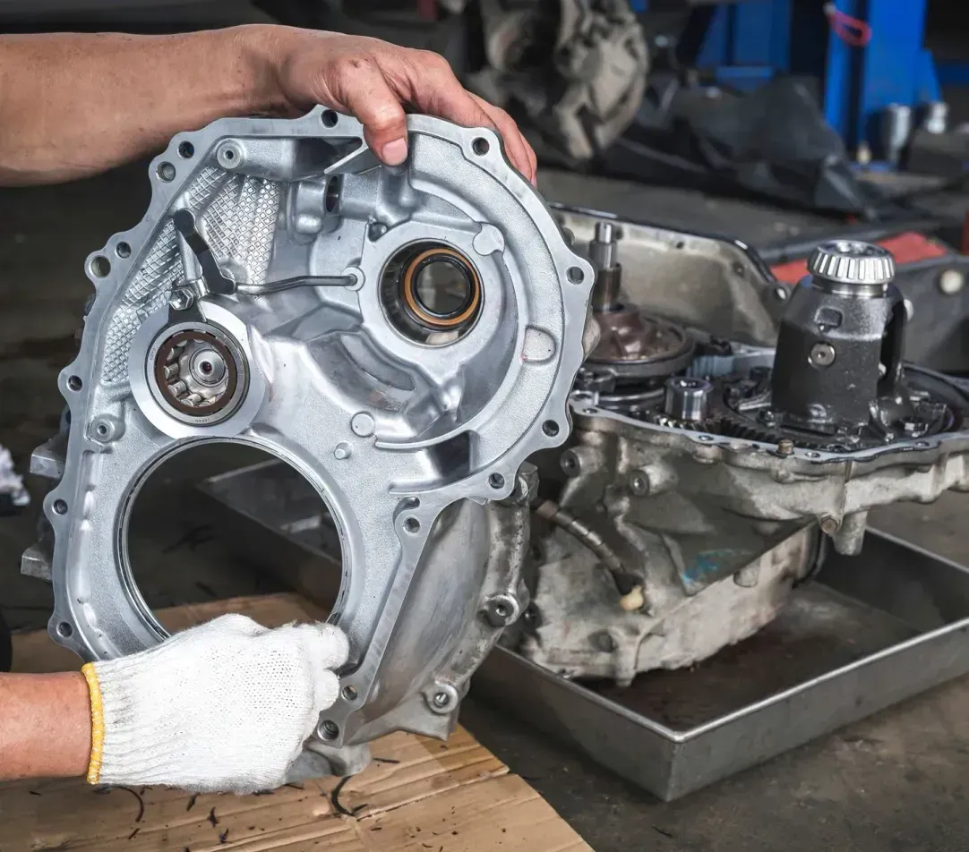 A man is working on a car engine in a garage.