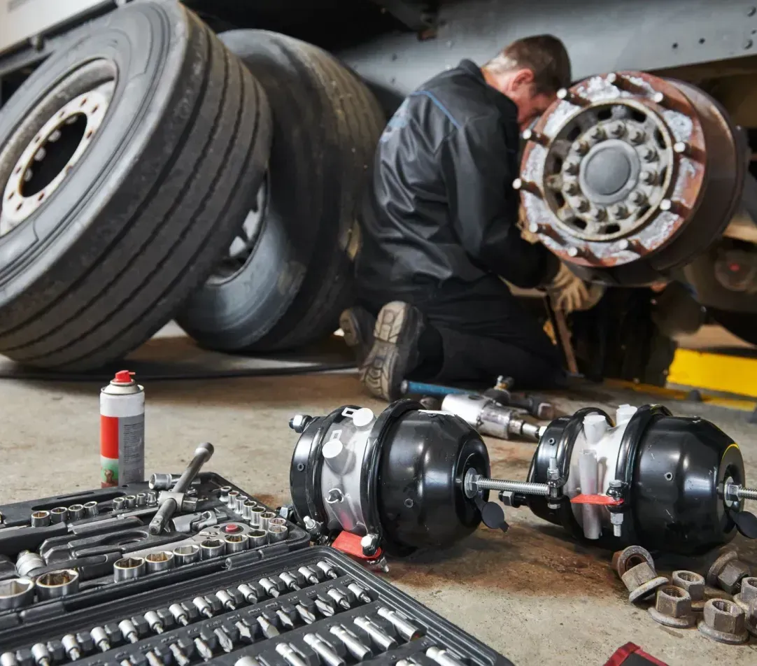A man is working on a truck in a garage.