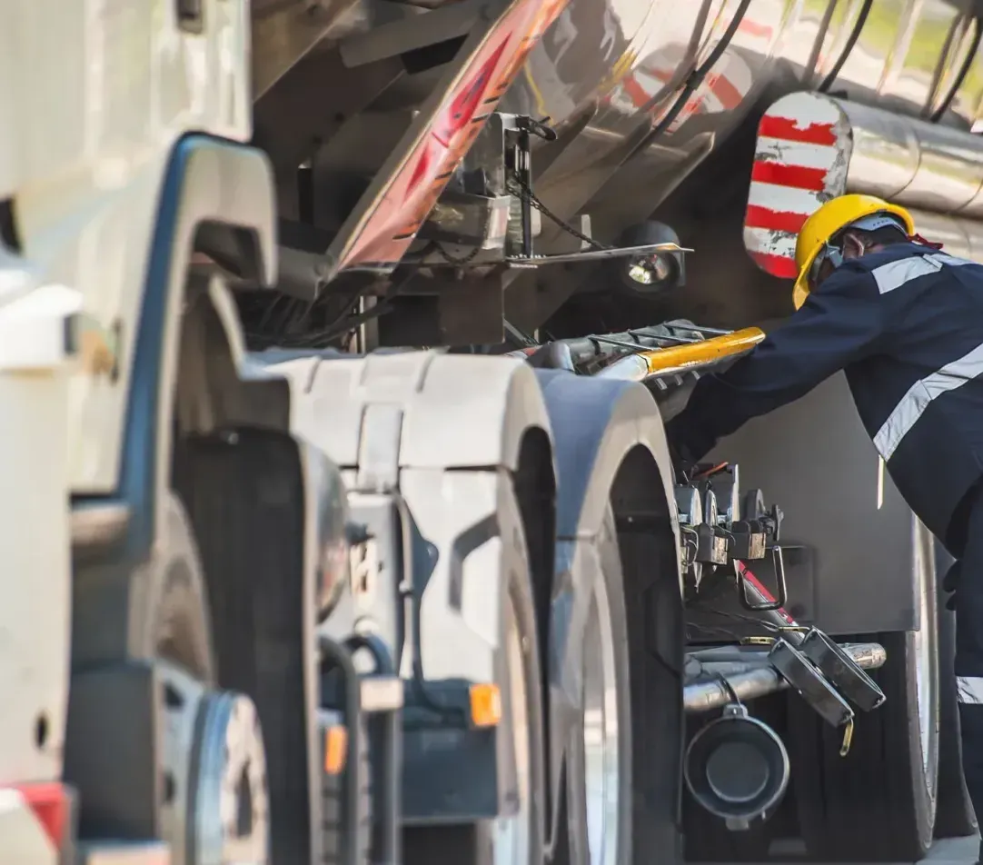 A man is working on the engine of a truck.