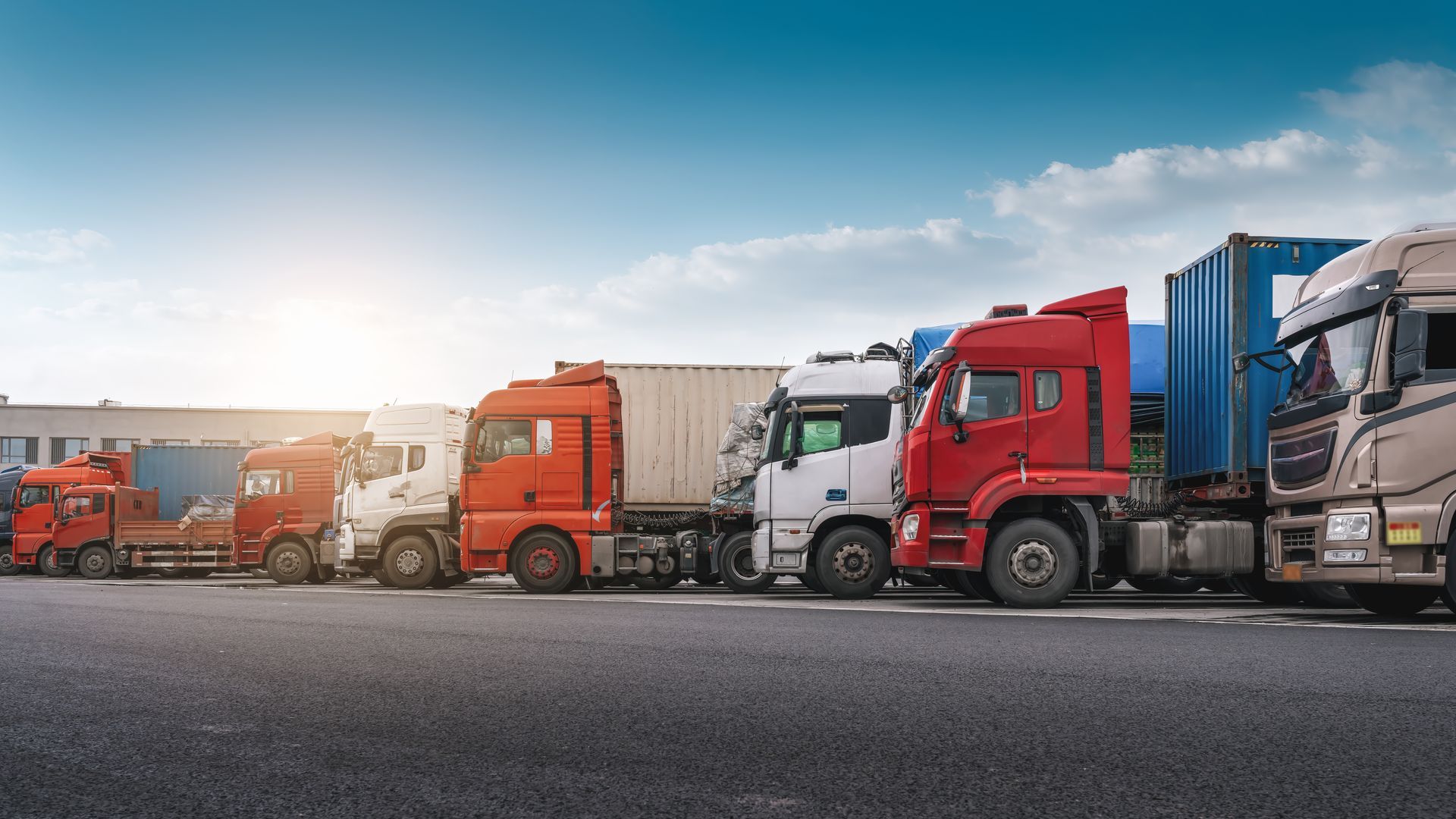 A row of semi trucks parked on the side of the road.