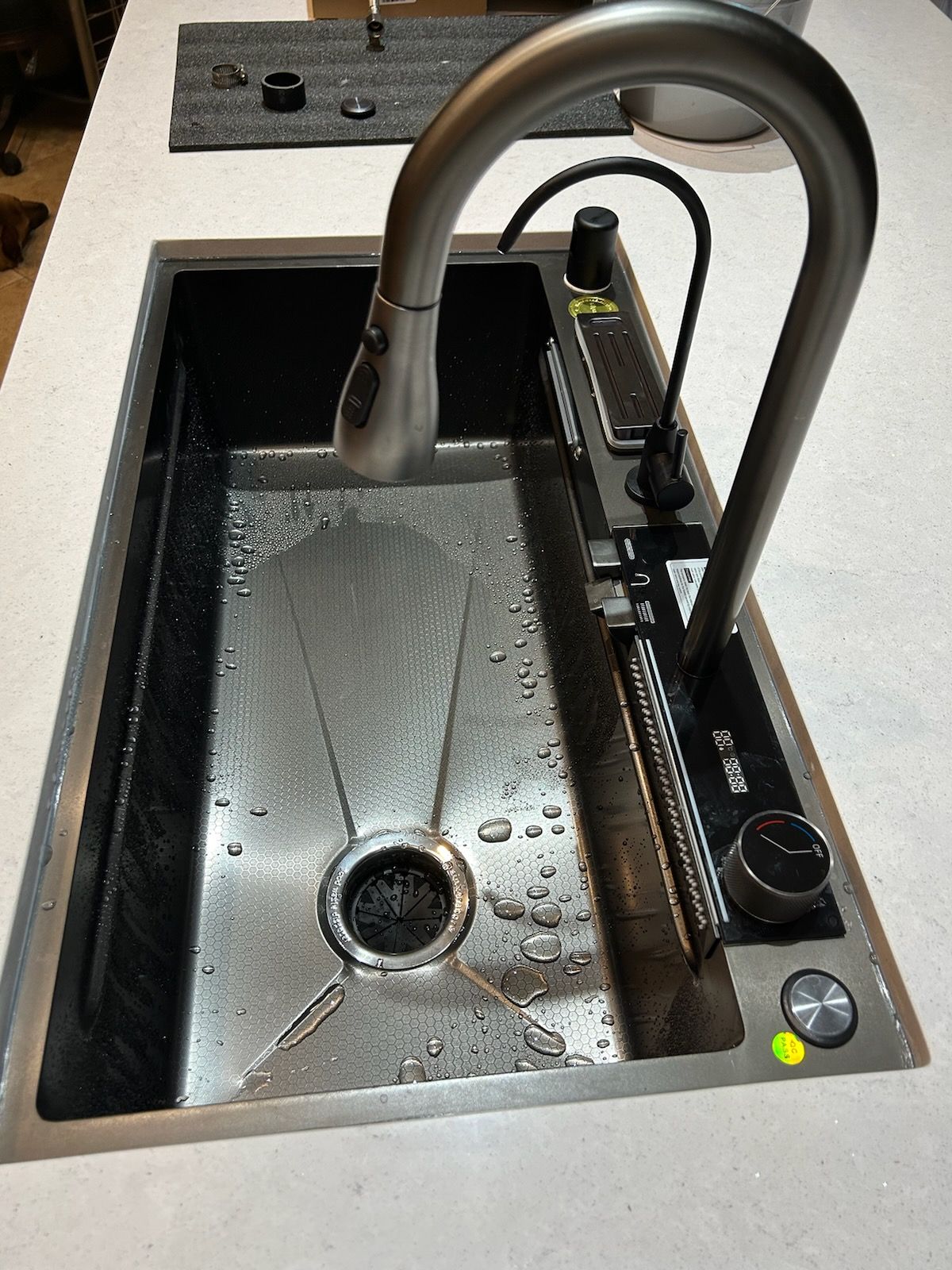 A stainless steel kitchen sink with a faucet