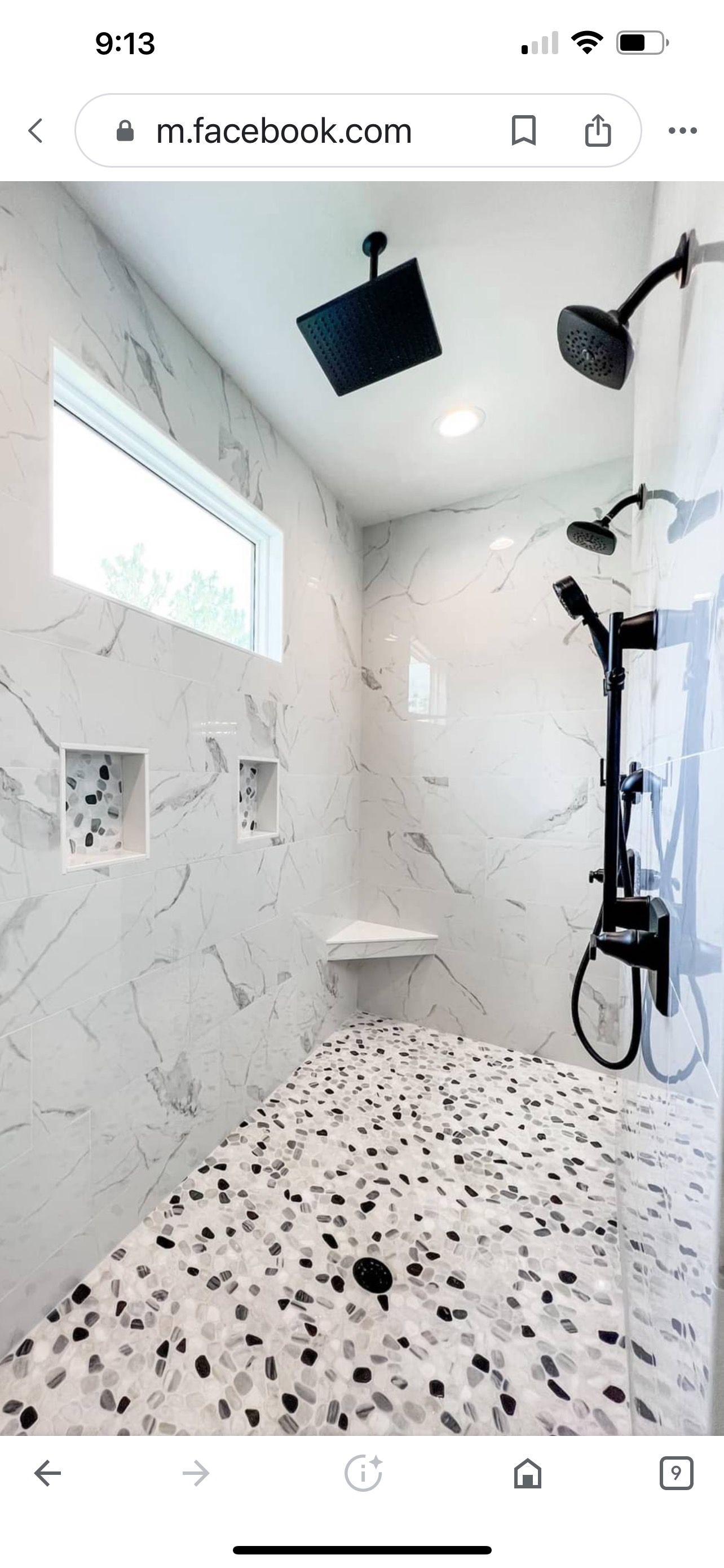 A bathroom with a walk in shower and a window.