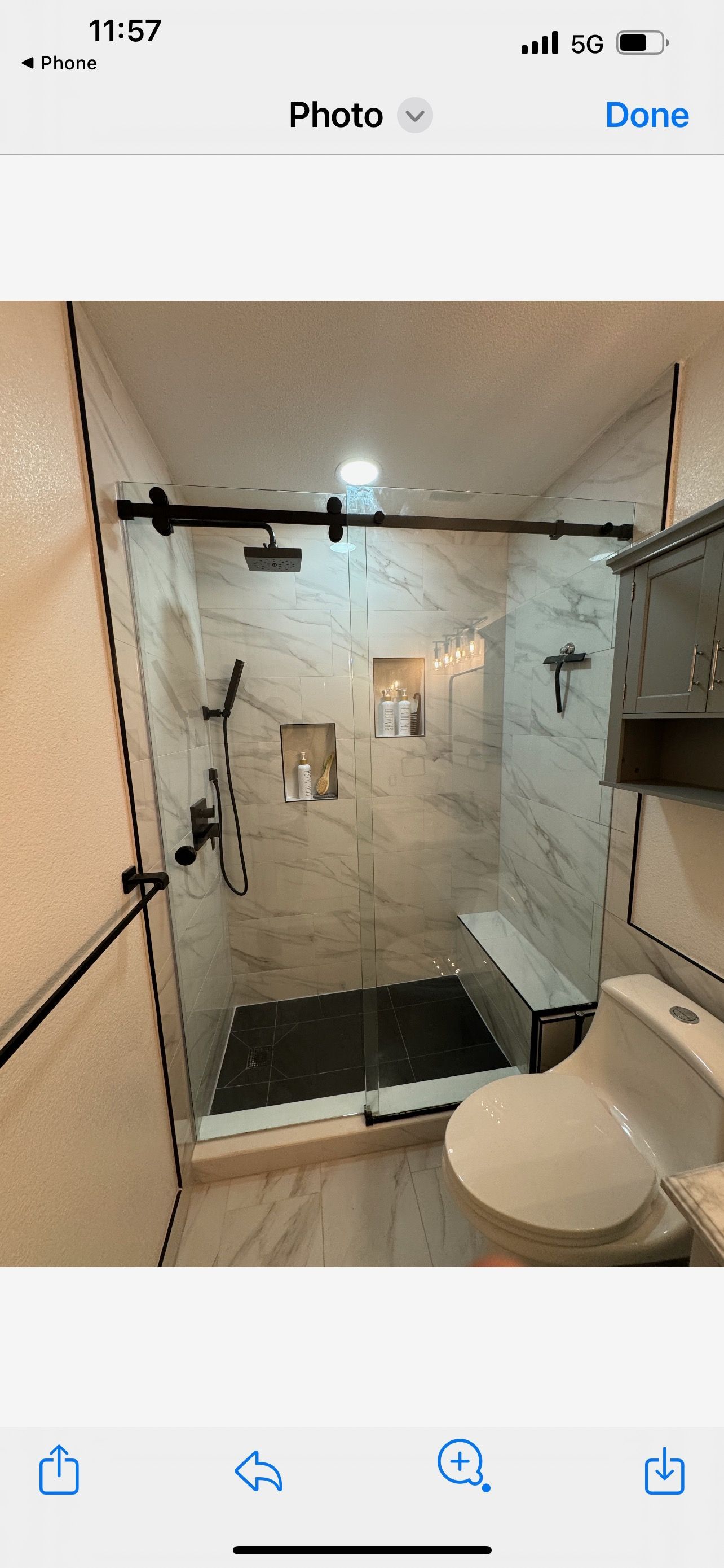 A bathroom with a sliding glass shower door and a toilet.