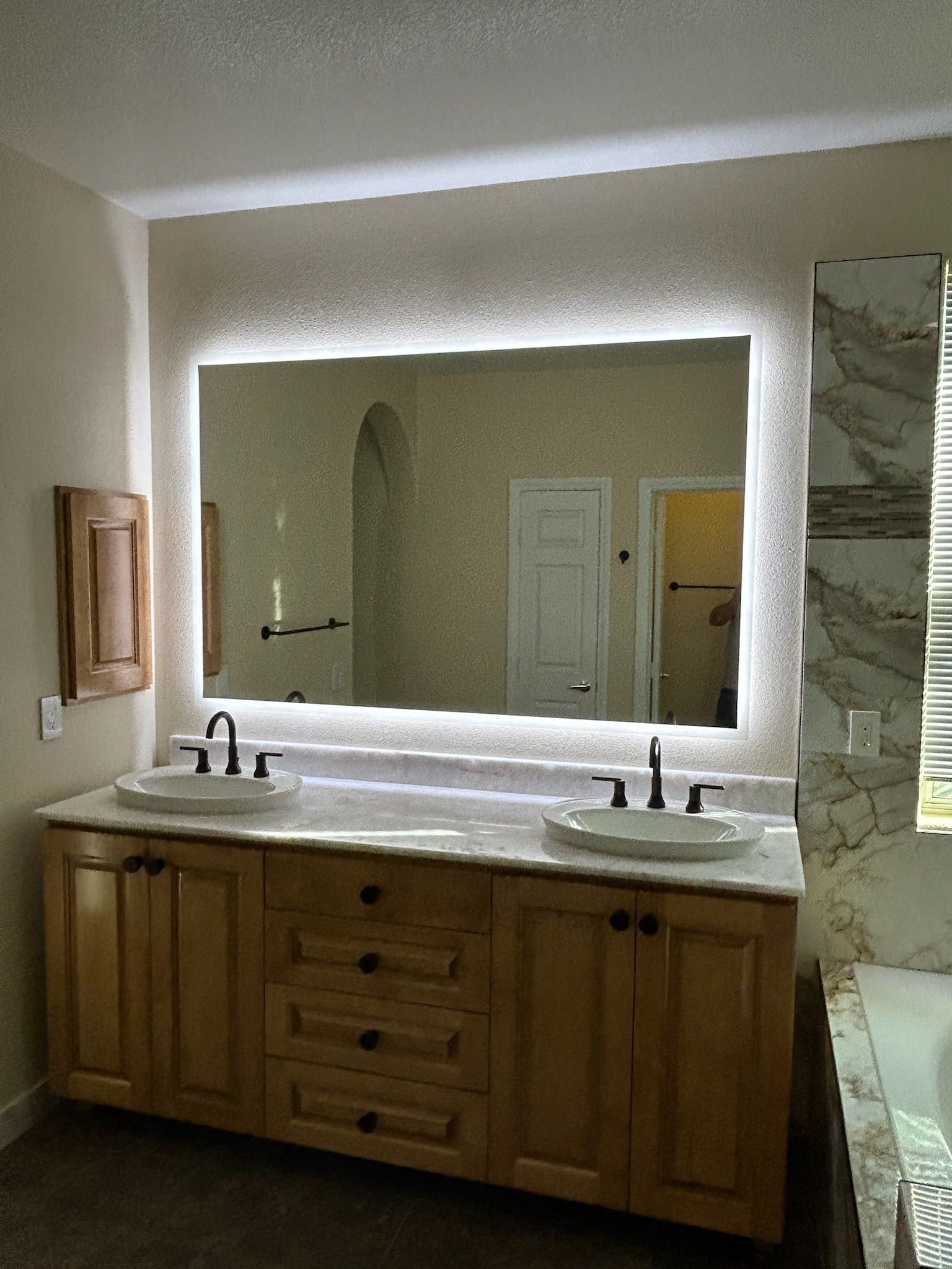 A bathroom with two sinks and a large mirror